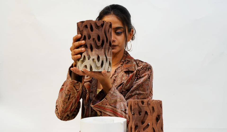 Rameshwari Jonnalagadda holding a clay 3D printed structure designed for efficient building cooling, showcasing innovative architectural solutions.