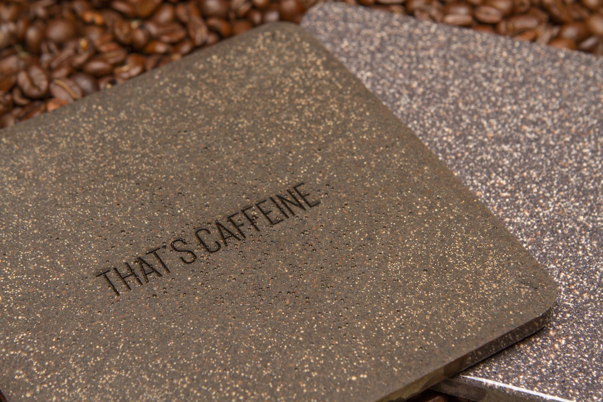 Coasters made from sustainable materials, featuring a message about caffeine, resting on coffee beans.