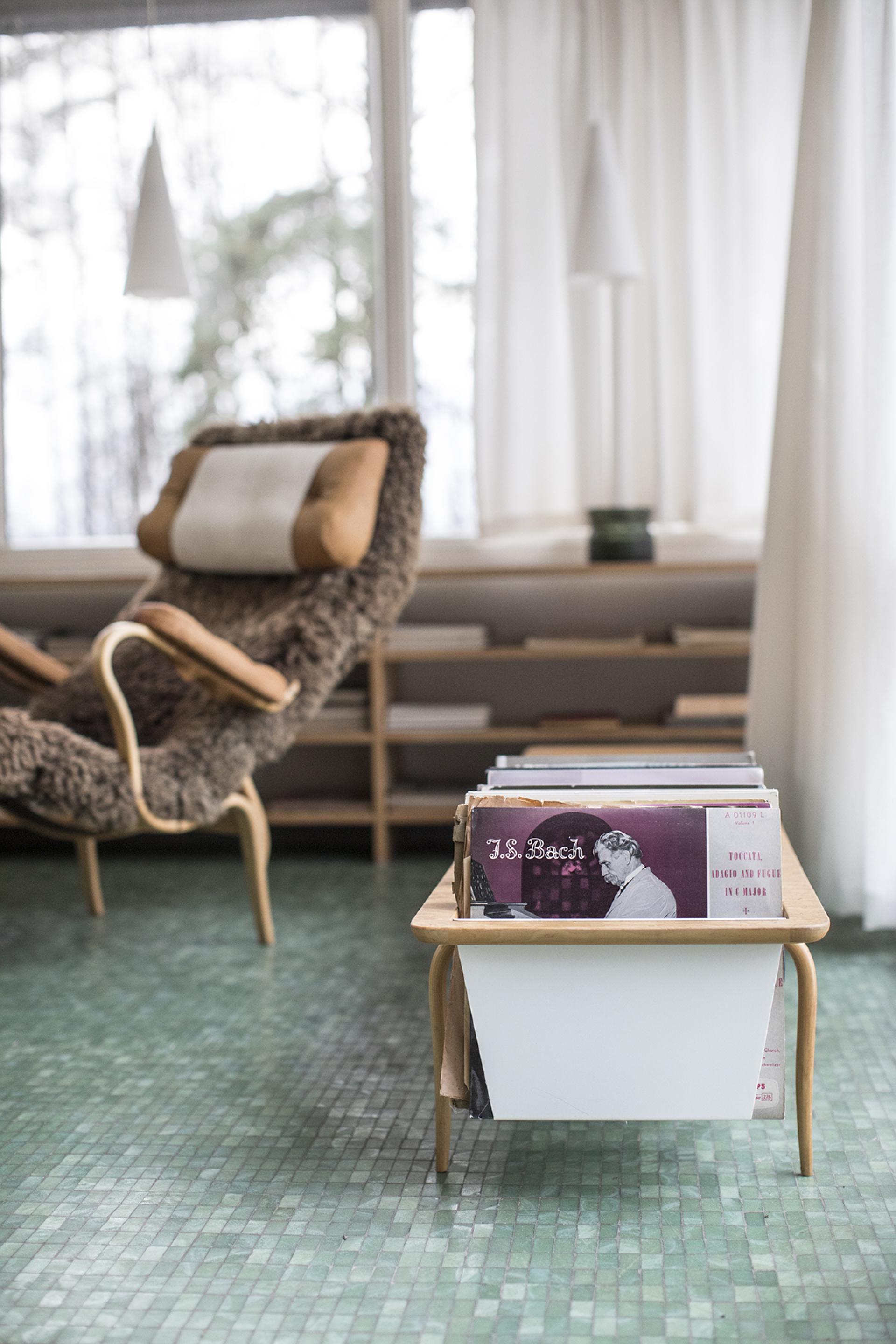 Elegant interior of Södra Kull featuring a cozy chair and vinyl record collection, highlighting Swedish design heritage.