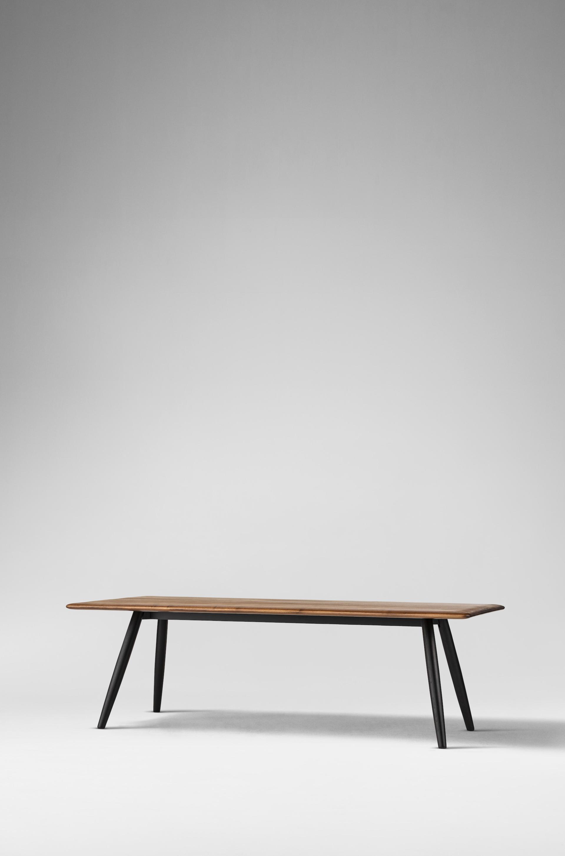 Minimalist wooden table with sleek black legs, embodying Japanese design principles highlighted in Ritzwell's latest collection.