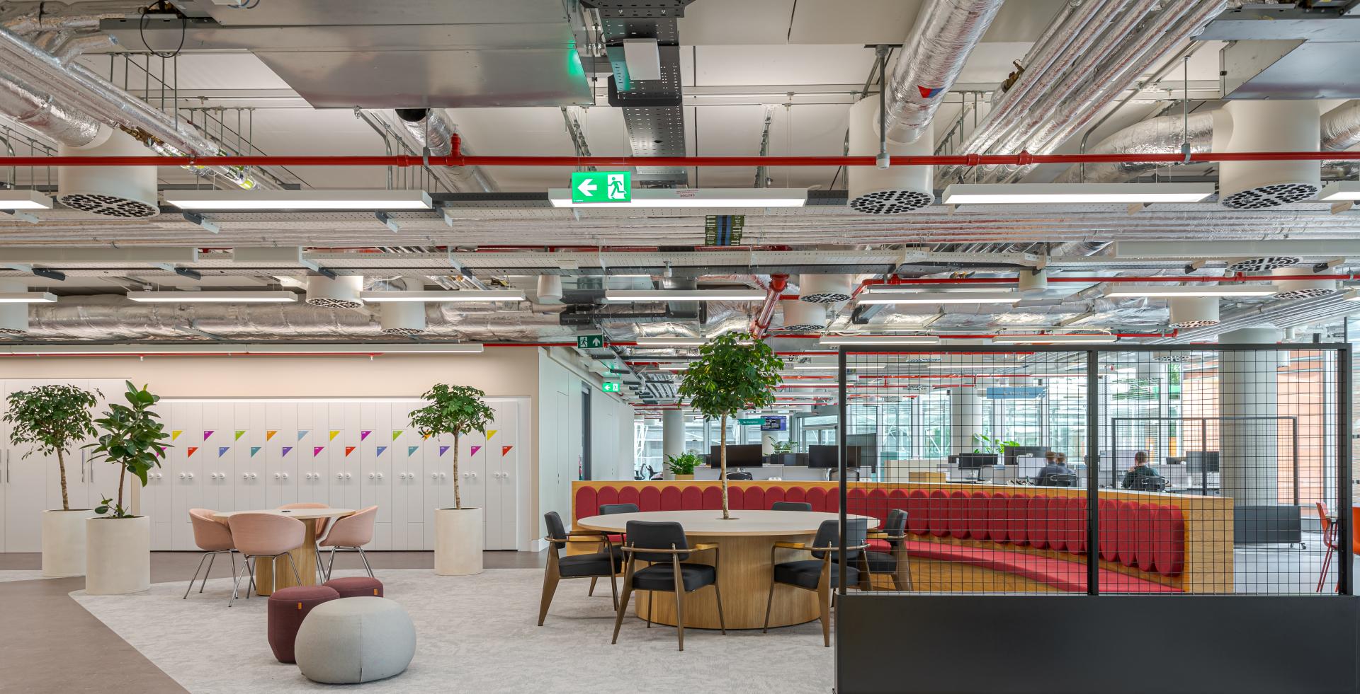 Modern collaborative workspace at Landsec headquarters featuring flexible seating, greenery, and vibrant design elements for community engagement.