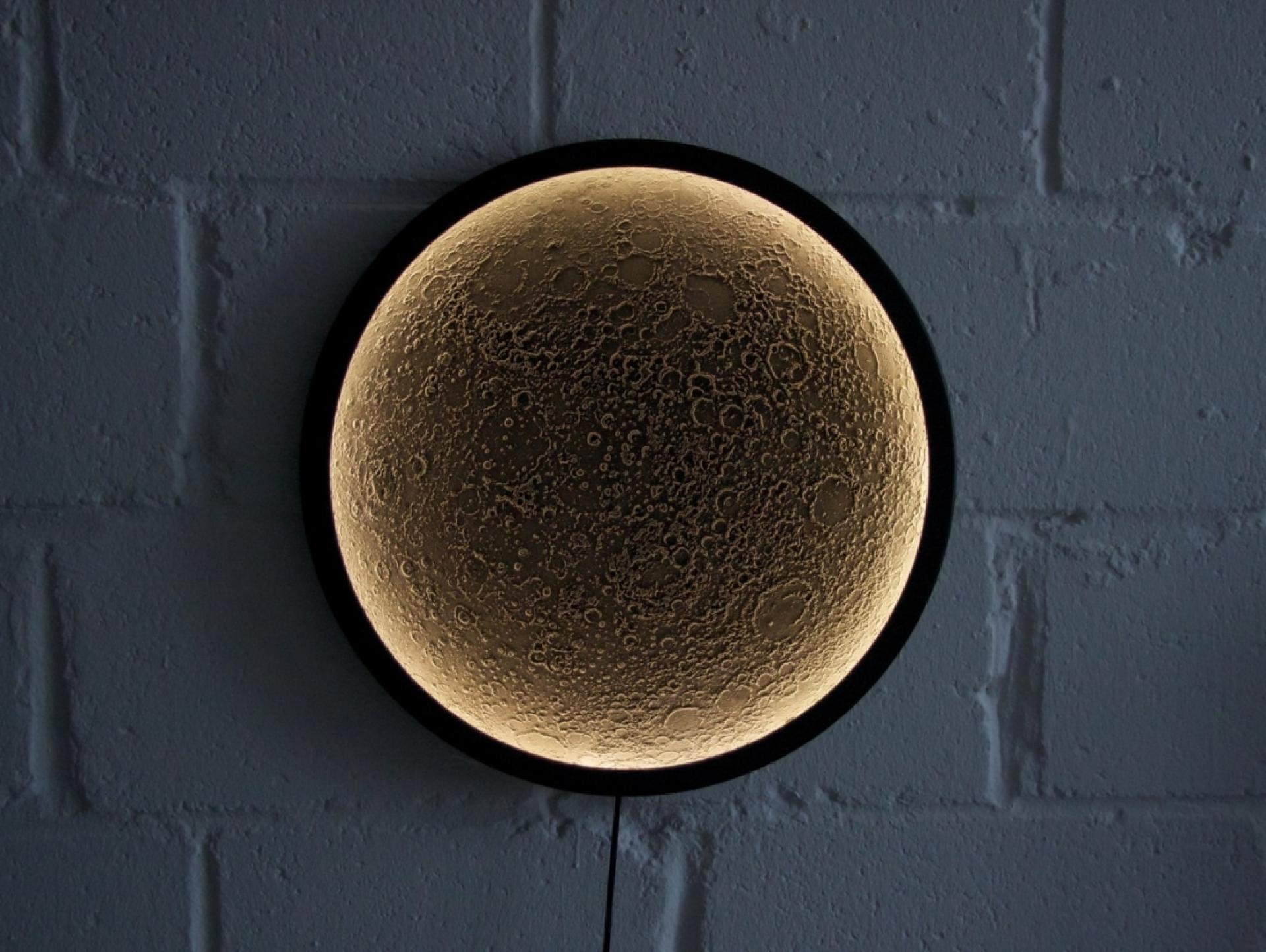 Illuminated moon wall art featuring detailed lunar surface textures, showcasing sustainable design concepts at London Design Festival 2018.