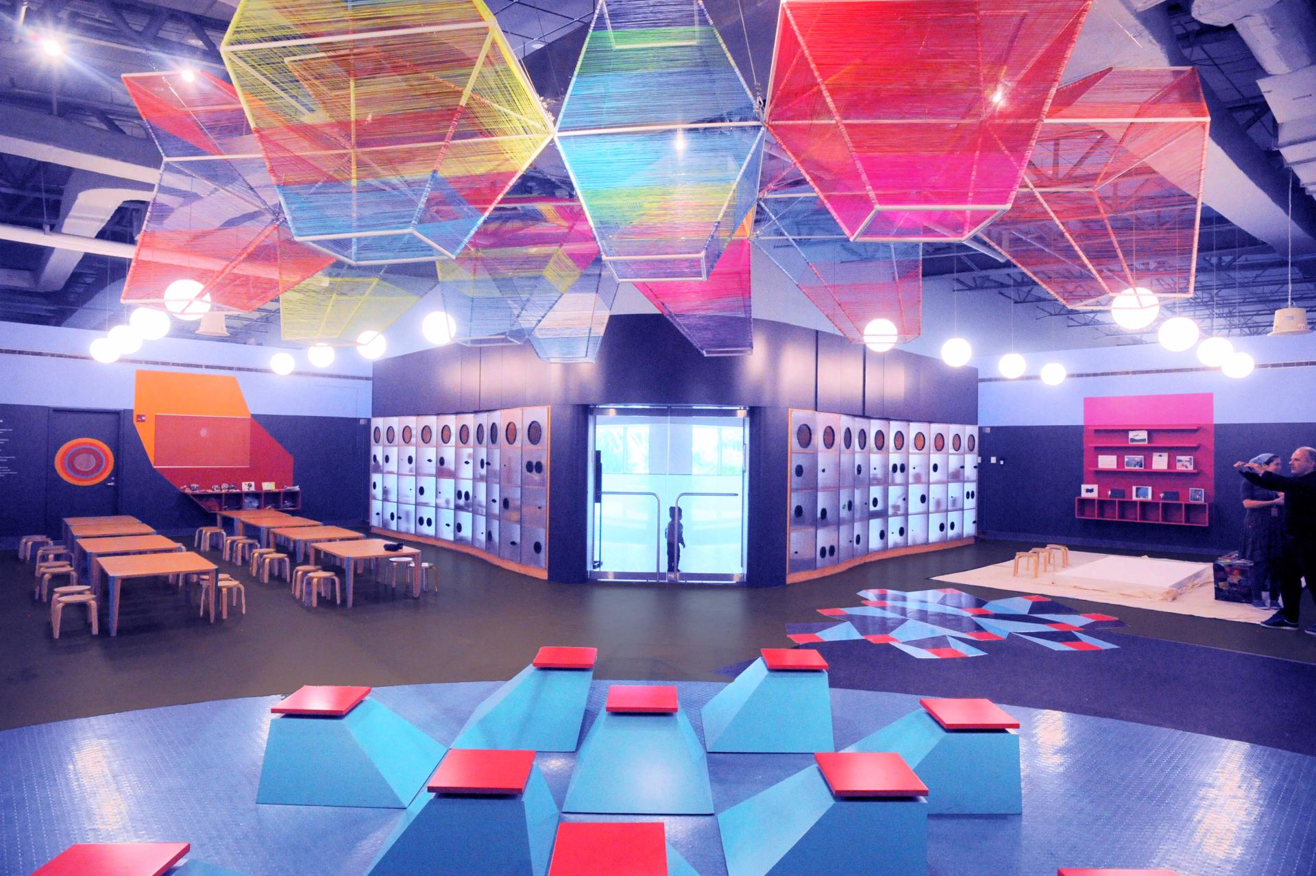 Brightly colored art-making space for children, featuring creative seating and vibrant geometric designs at SLO Architecture's ColorLab in Brooklyn.