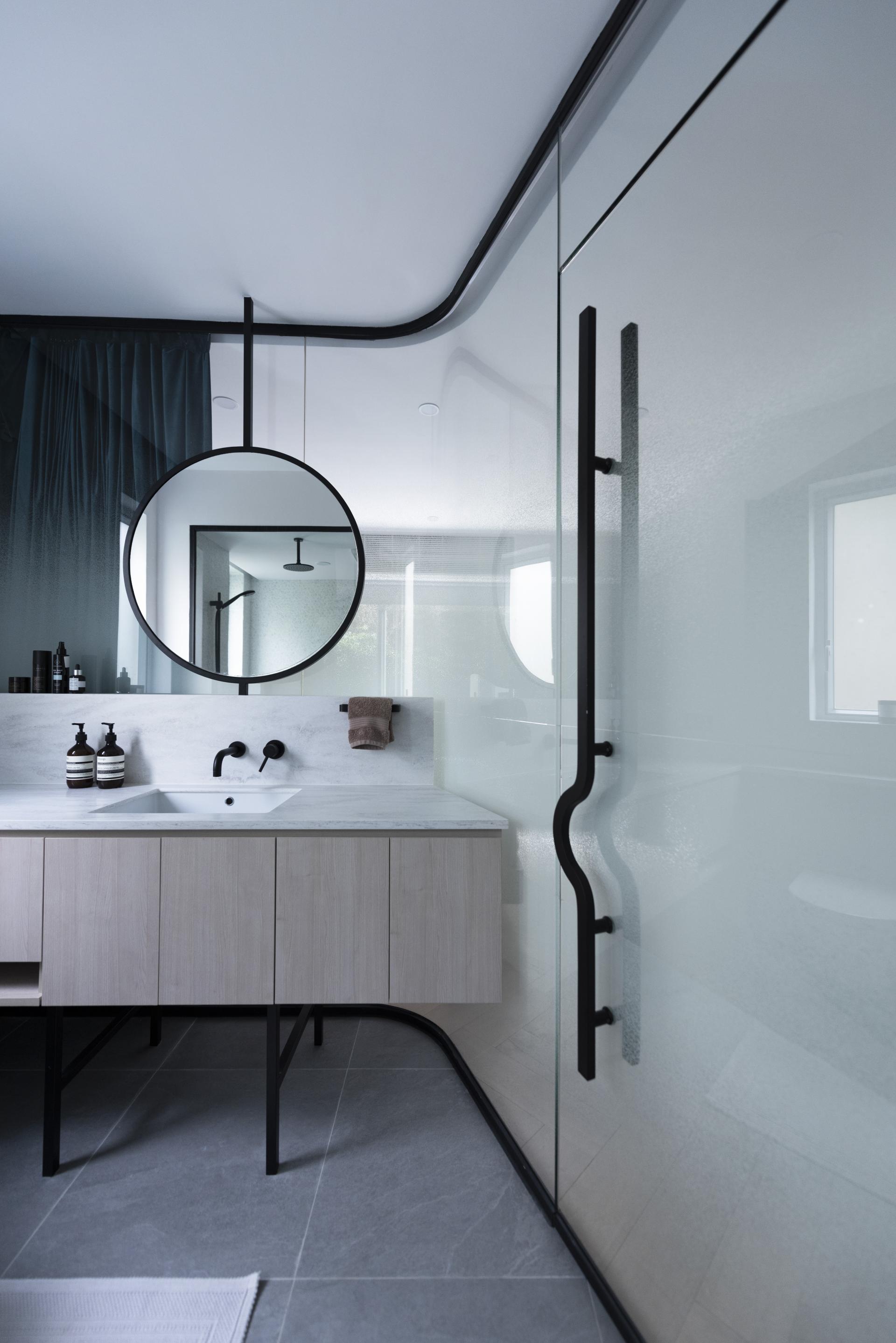 Modern bathroom design featuring a sleek black mirror, minimalist cabinetry, and elegant fixtures at Beau Cloud Mansion.