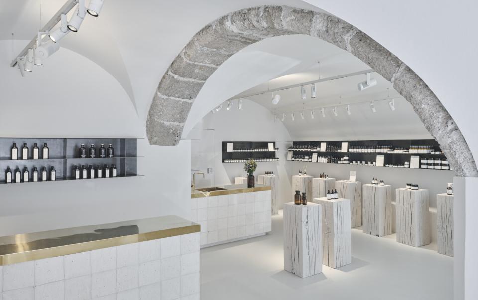 Stylish interior of Saint Charles store in Salzburg, featuring natural cosmetics displayed on minimalist shelving and stone pedestals.
