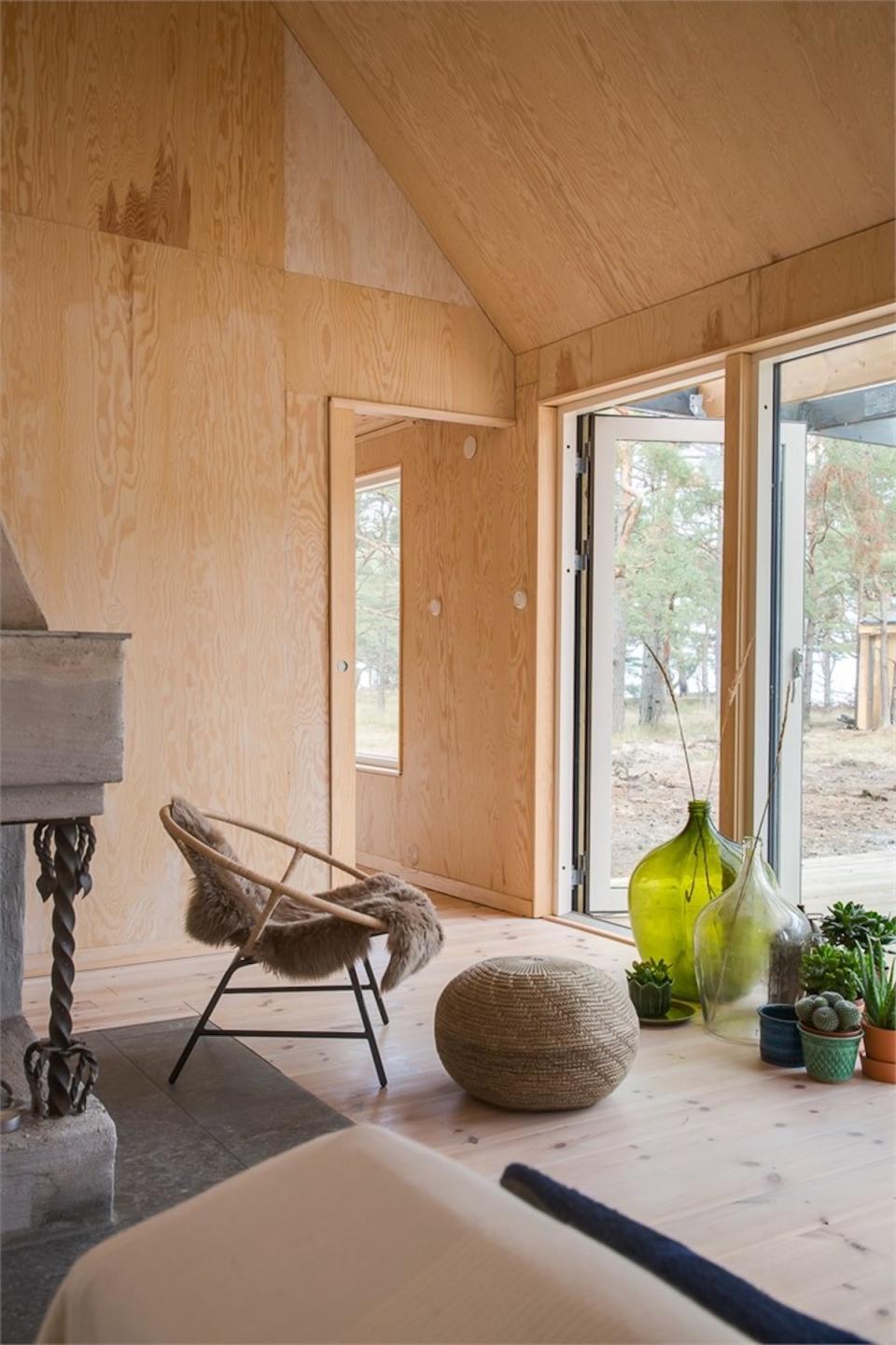 Stylish Scandinavian interior featuring natural wood walls, modern furniture, and green accents in a serene environment.