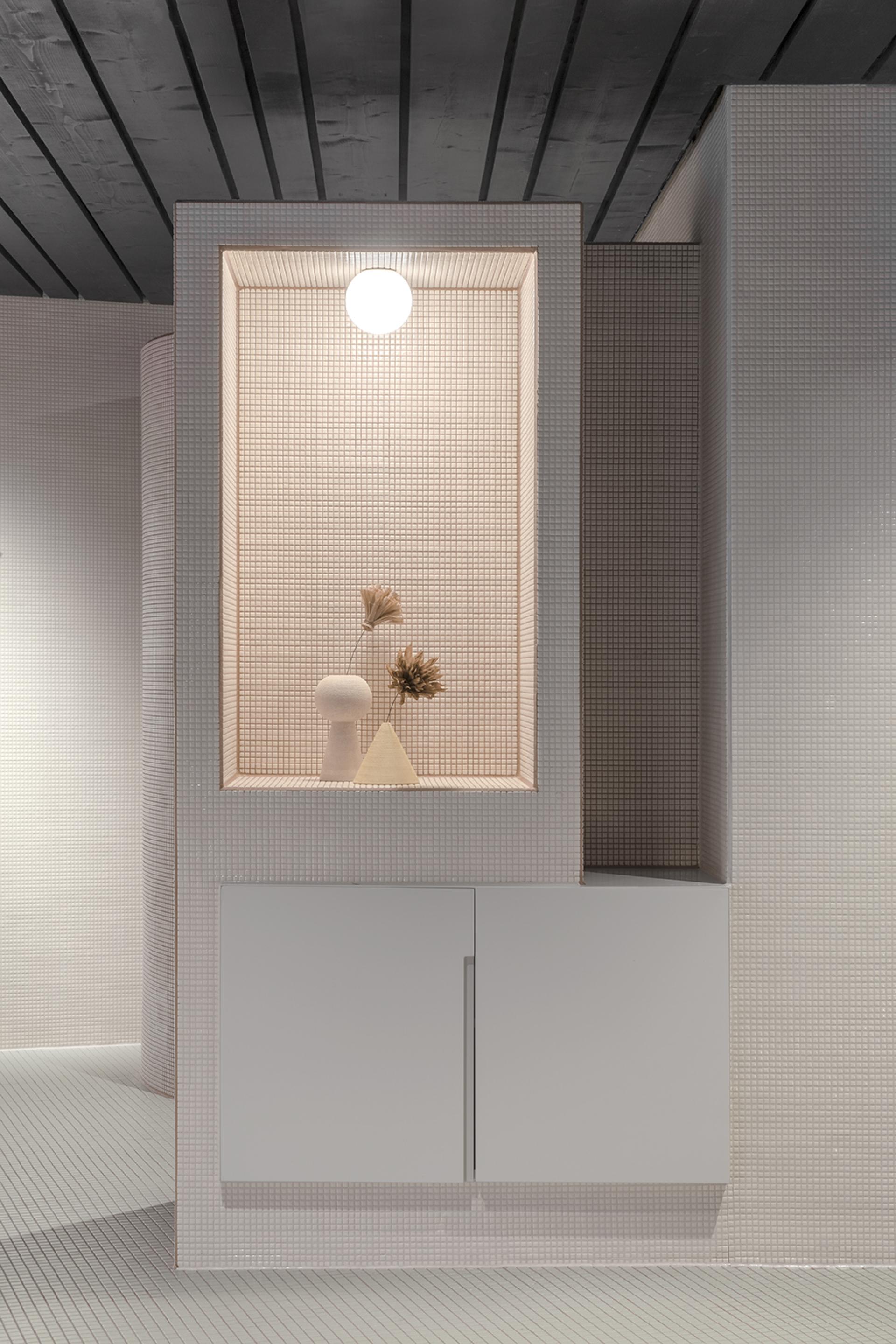 Modern interior design featuring a tiled display nook with decorative objects, emphasizing alpine heritage and artistic elegance.