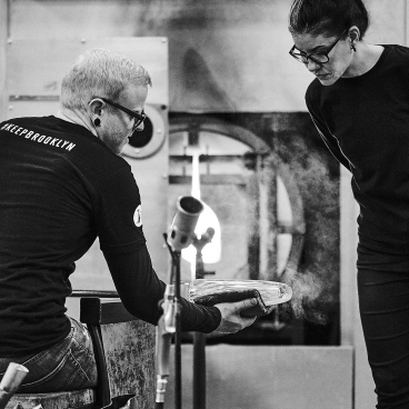 Glass artisans Susan Spiranovich and Adam collaborate in the KEEP Brooklyn studio, focusing on glassblowing techniques.