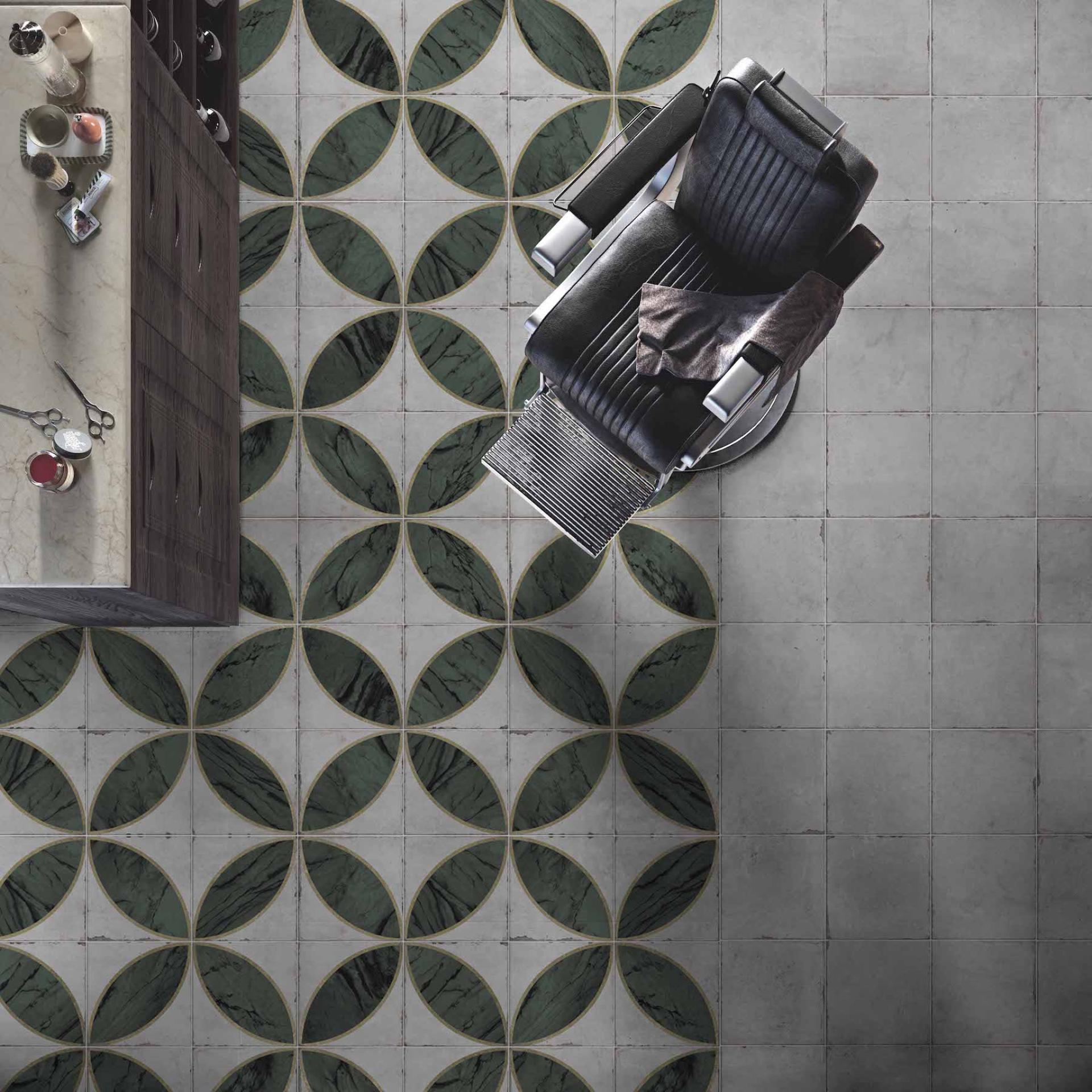 Stylish black barber chair on decorative green and gray patterned tile floor, showcasing modern tile design trends.