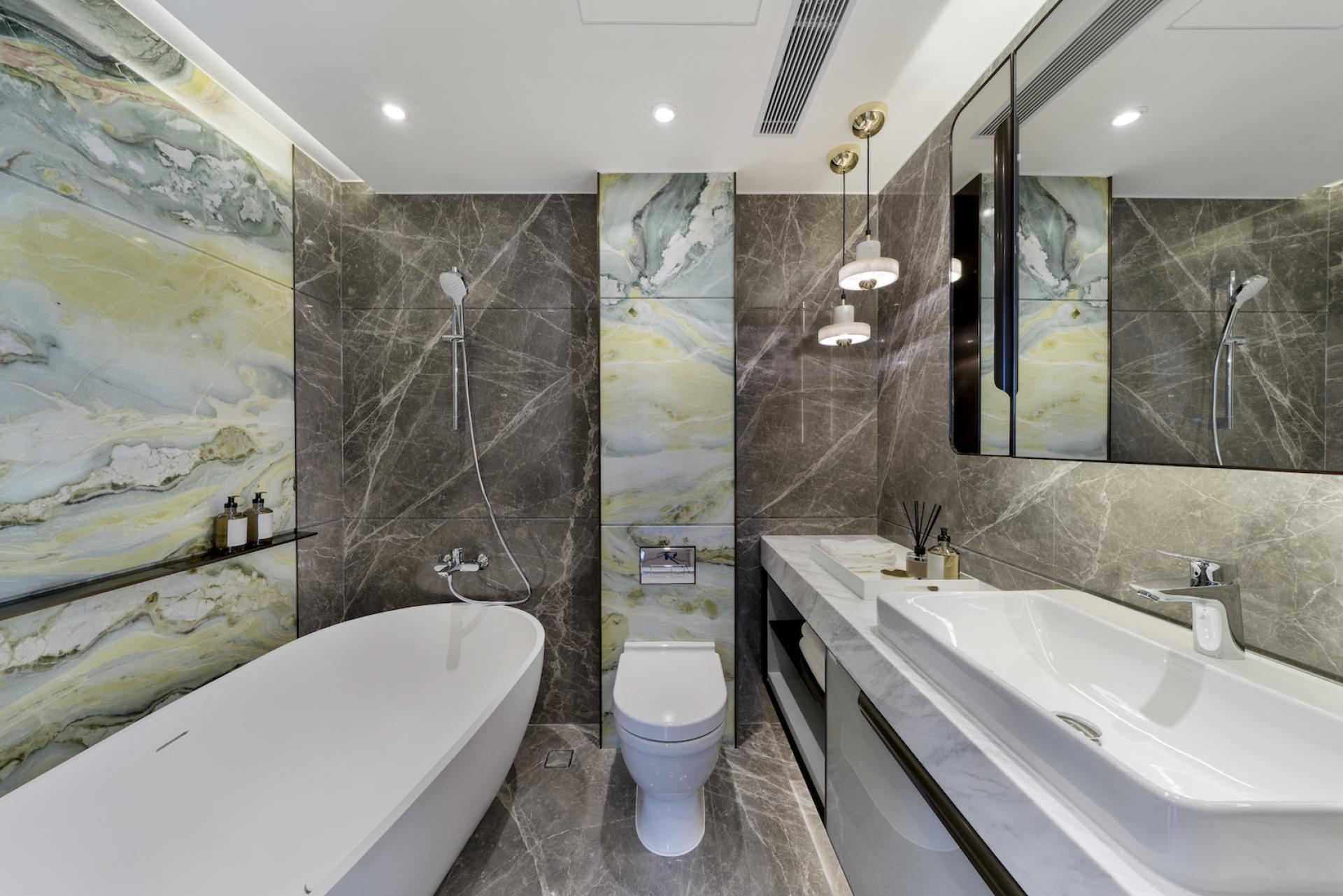 Stylish bathroom featuring a freestanding tub, elegant marble walls, and modern fixtures, reflecting harmonious interior design principles.