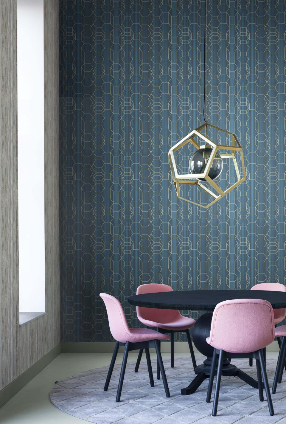 Elegant dining area featuring Tektura Wallcoverings' geometric patterned wallpaper, complemented by pink chairs and a modern light fixture.