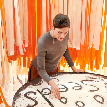 Marije Vogelzang interacts with a tactile food art installation, symbolizing the relationship between design and culinary experiences.