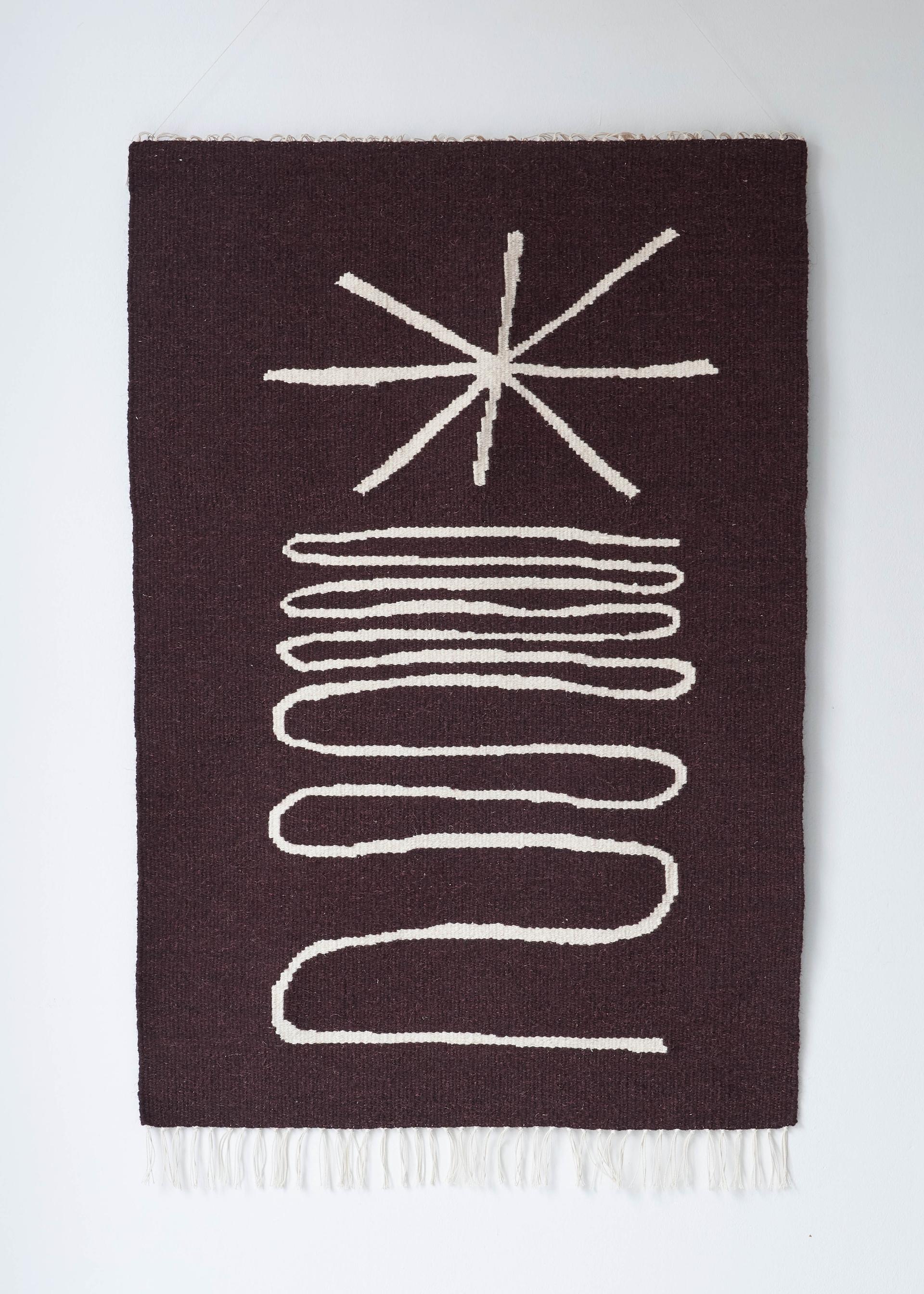 Tapestry artwork featuring a star design above wavy lines, showcasing Christabel Balfour's weaving craft and inspiration.
