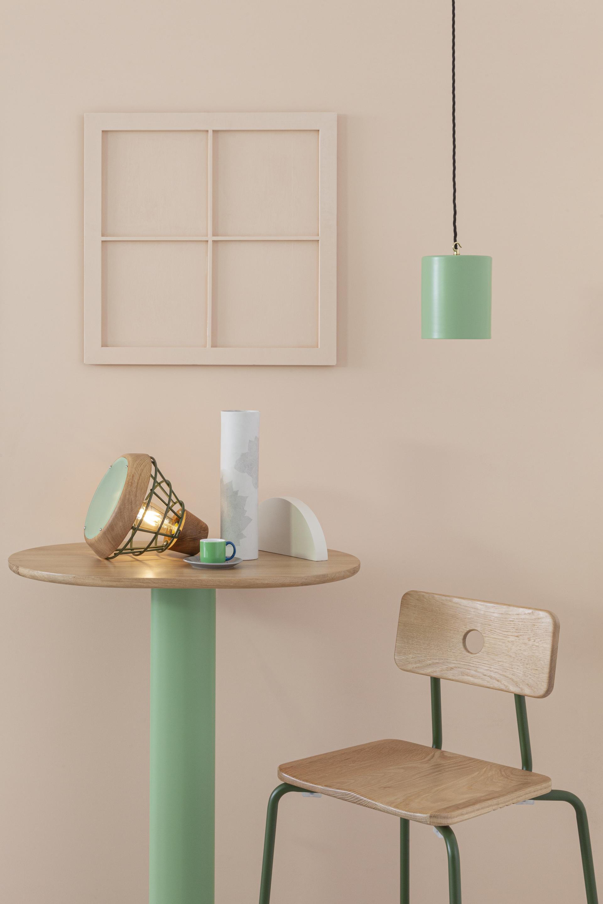 Stylish green pendant light and modern furniture showcase Liqui Contracts' innovative design collection at 100% Design.