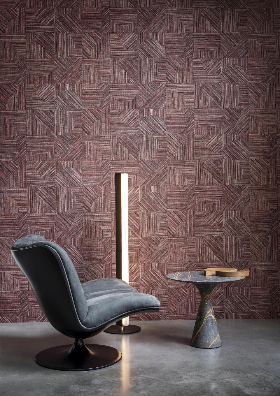 Stylish gray chair and marble side table against a textured, puzzle-inspired wallpaper from Arte's Tangram collection.