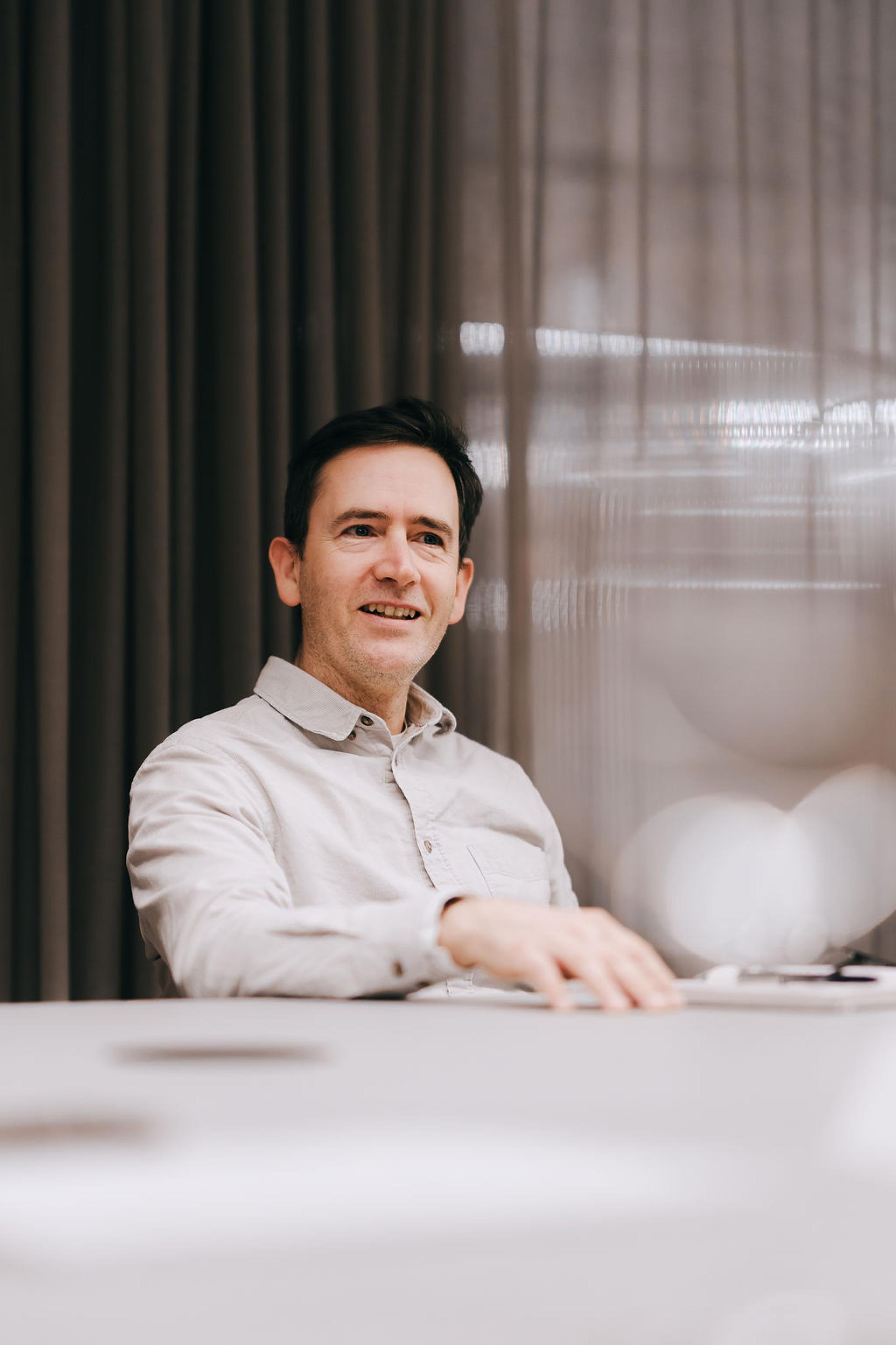 Man engaging in a discussion about sustainable biomaterials at a conference, with a focus on innovation and environmental impact.