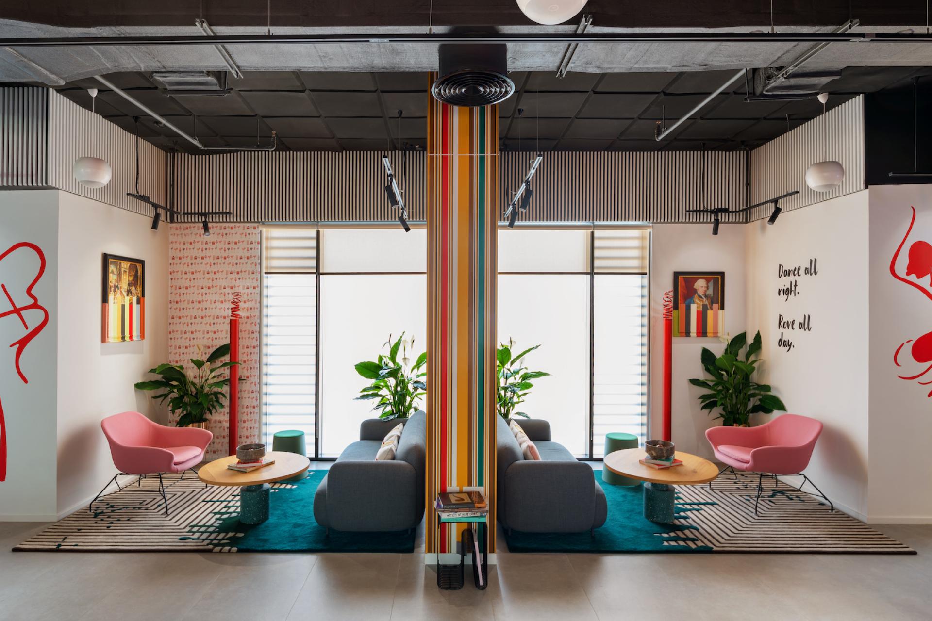 Stylish lounge area featuring colorful decor, modern furniture, and plants, reflecting H2R's design philosophy of elegance and playfulness.