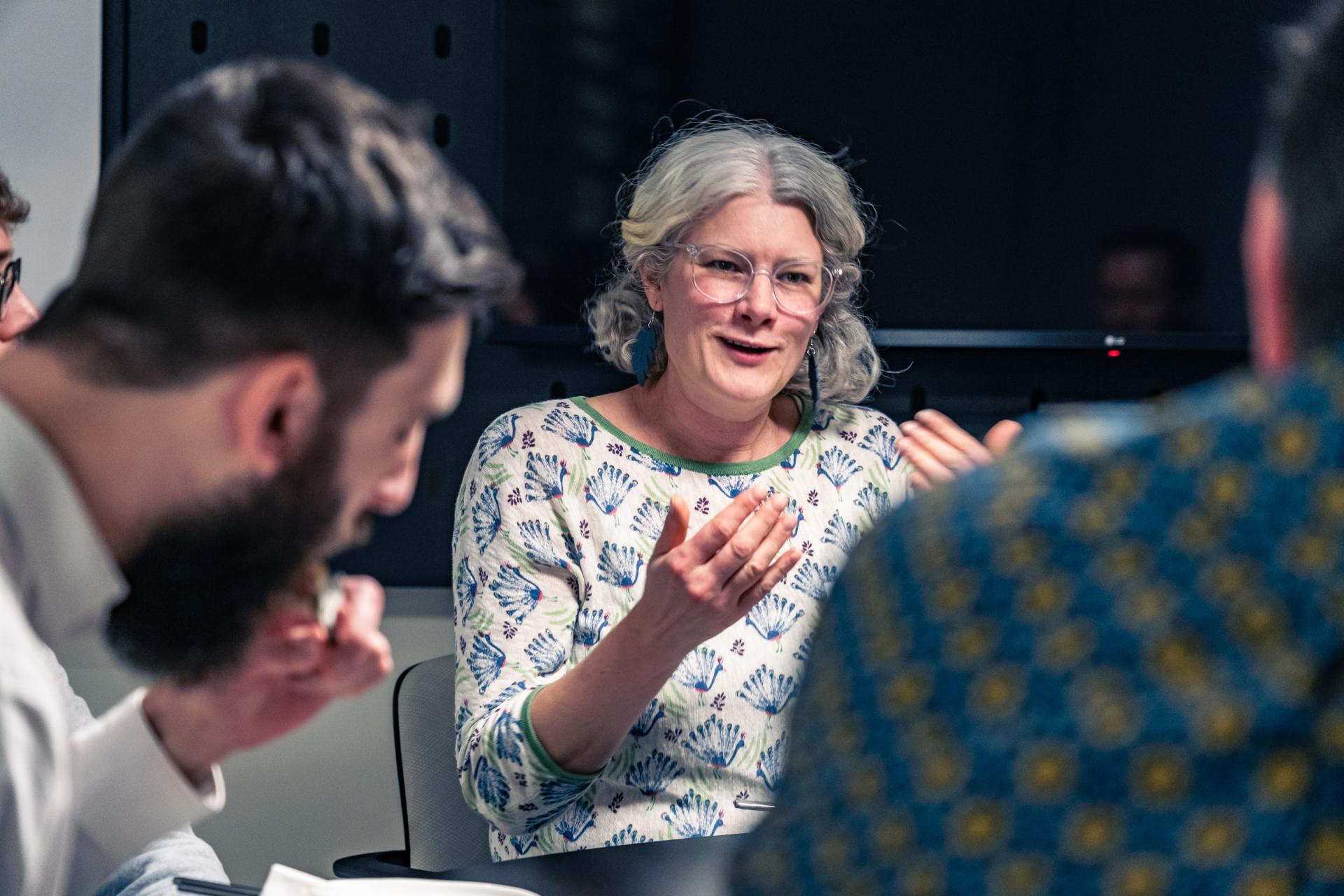 Engaged discussion on sustainability, featuring a woman explaining concepts related to achieving Net Zero goals.