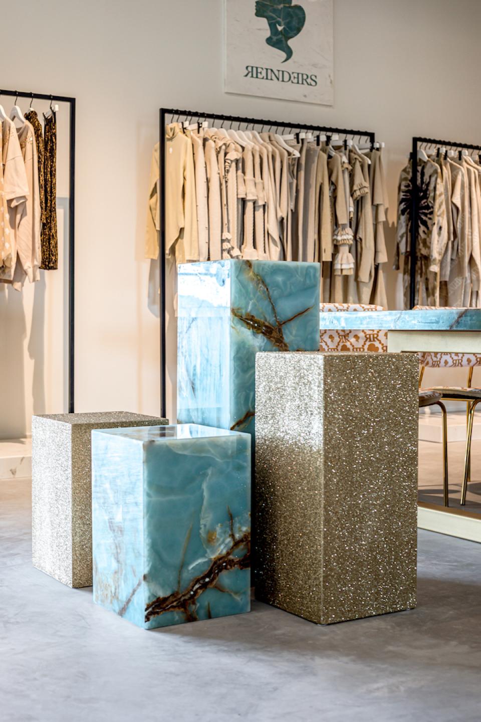 Marble furniture pieces featuring blue and glitter finishes showcased in Reinders' stylish showroom in the Netherlands.