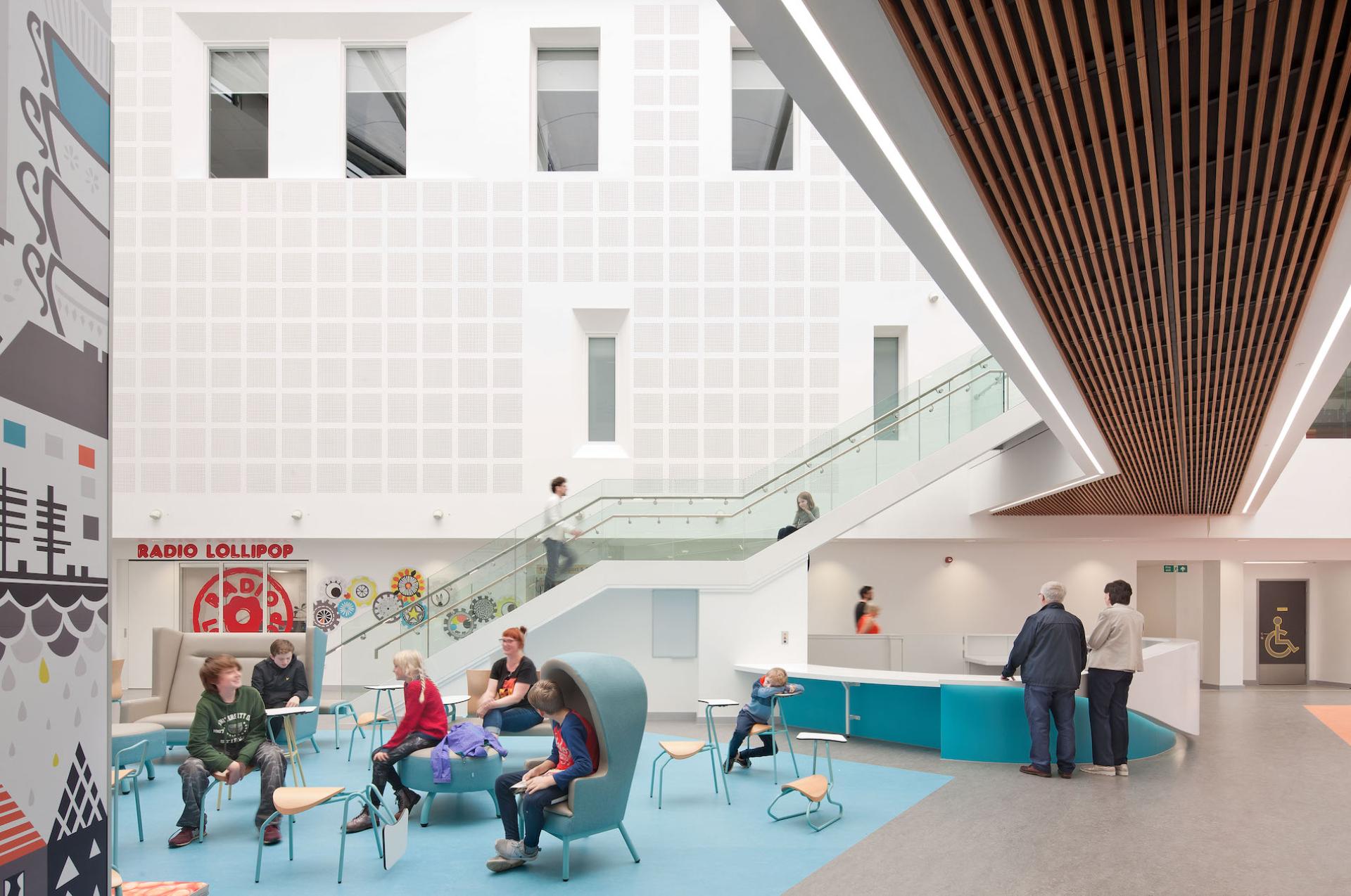Bright and welcoming healthcare lobby in NHS Lothian, featuring modern seating, children’s play area, and large stairs.