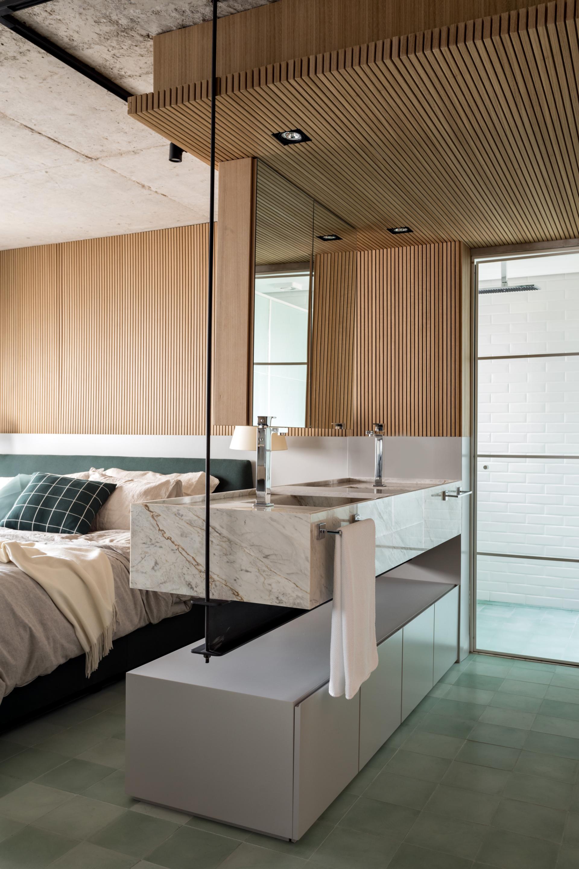 Modern integrated apartment design featuring a sleek marble sink and wood-paneled walls in São Paulo's Vila Madalena neighborhood.