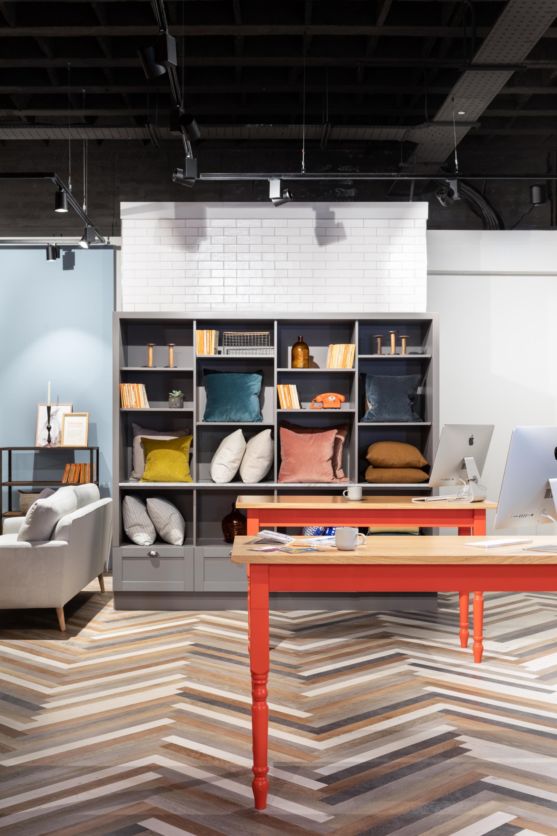 Modern interior featuring Karndean luxury vinyl flooring, colorful cushions, stylish shelves, and a vibrant red table.