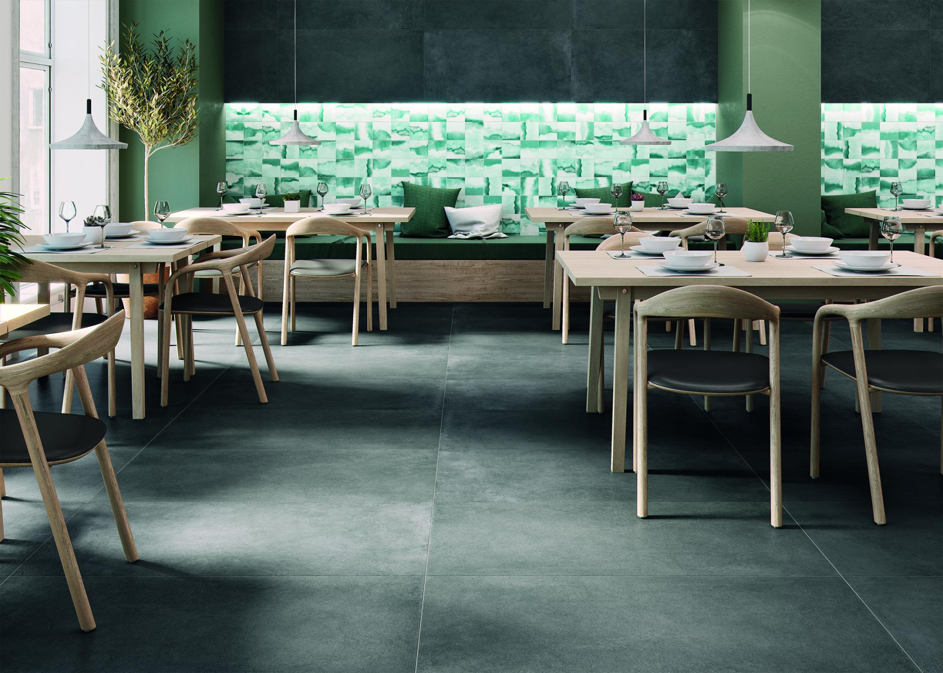 Modern dining area featuring Spanish tiles, wooden tables, and green accents, showcasing contemporary interior design trends.