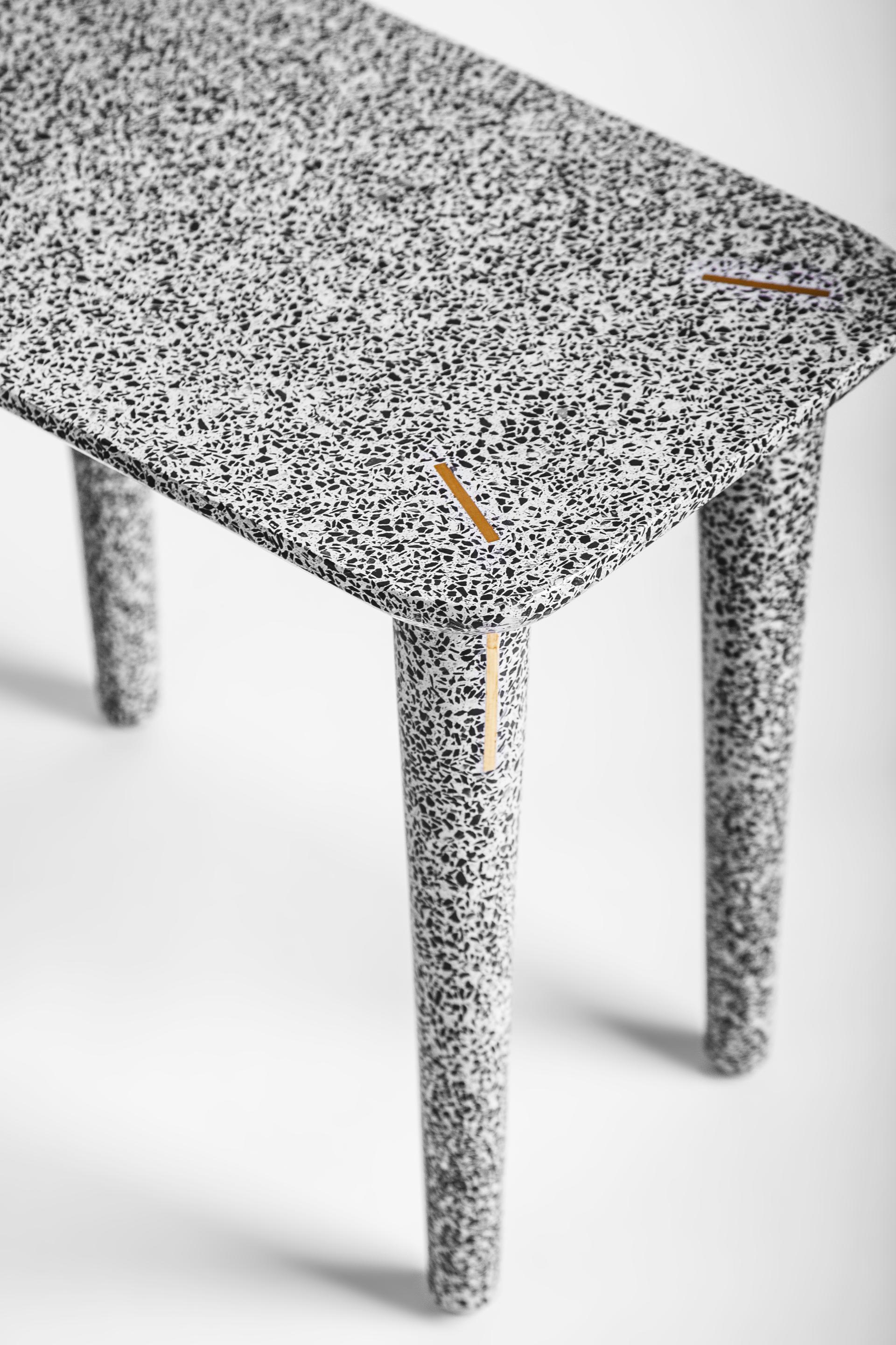 Terrazzo table from Joyce Wang's Flint collection, featuring a speckled surface and elegant detailing, showcasing contemporary design.