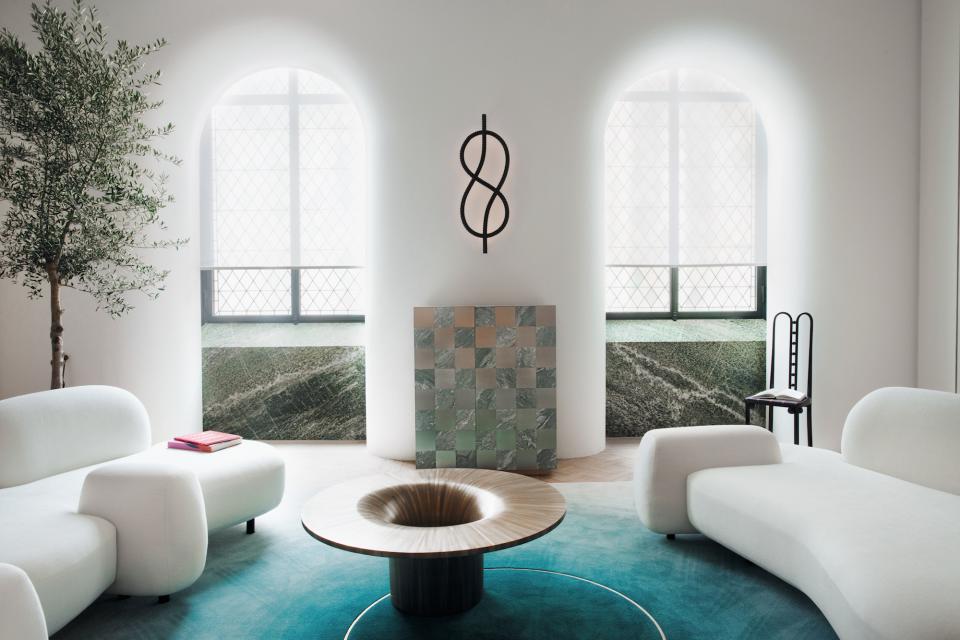 Modern interior featuring Mathieu Lehanneur's unique furniture collection, illuminated by natural light and accented by artistic symbols.