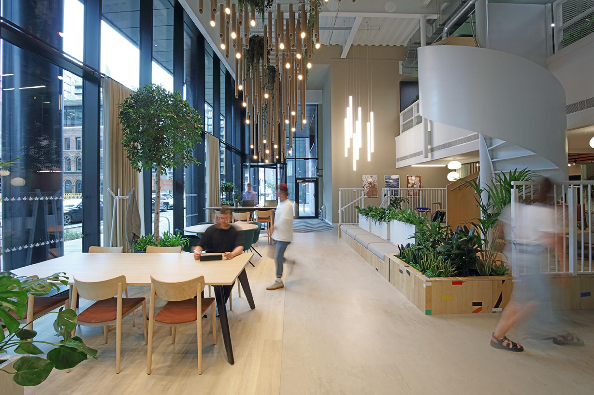 Modern social hub inside Eden, New Bailey featuring greenery, communal seating, and an inviting atmosphere for community engagement.