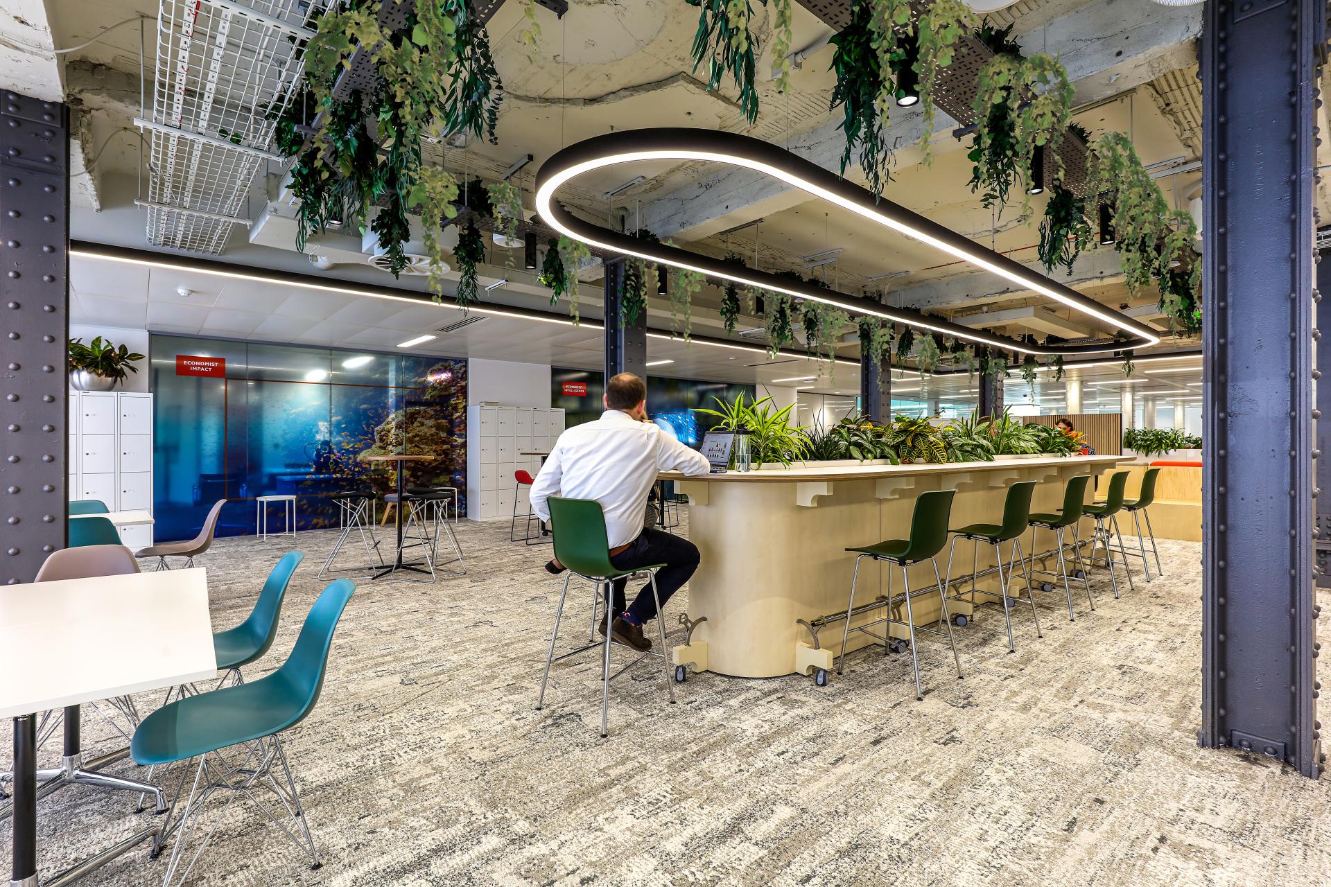 Modern office design features sustainable greenery and collaborative spaces in The Economist Group's low-carbon workspace.