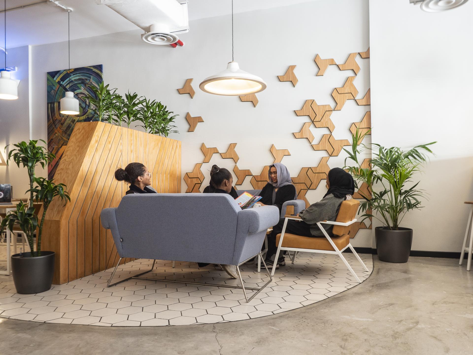 Modern interior design of Brew92 cafe featuring wooden elements, vibrant plants, and customers engaging in conversation.