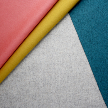 Colorful textiles, including pink, yellow, and teal fabrics, highlighting Camira's StaySafe advanced textile treatment innovation.