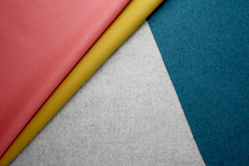 Colorful textiles, including pink, yellow, and teal fabrics, highlighting Camira's StaySafe advanced textile treatment innovation.
