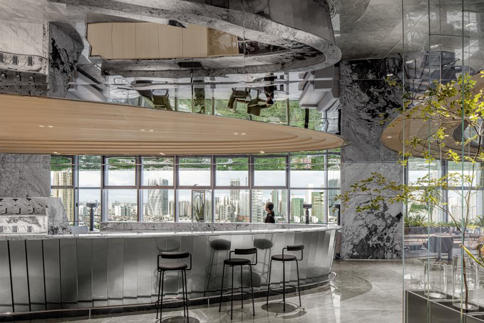 Modern bar interior design at Foshan Vanke Financial Centre, featuring marble surfaces and large windows with city views.