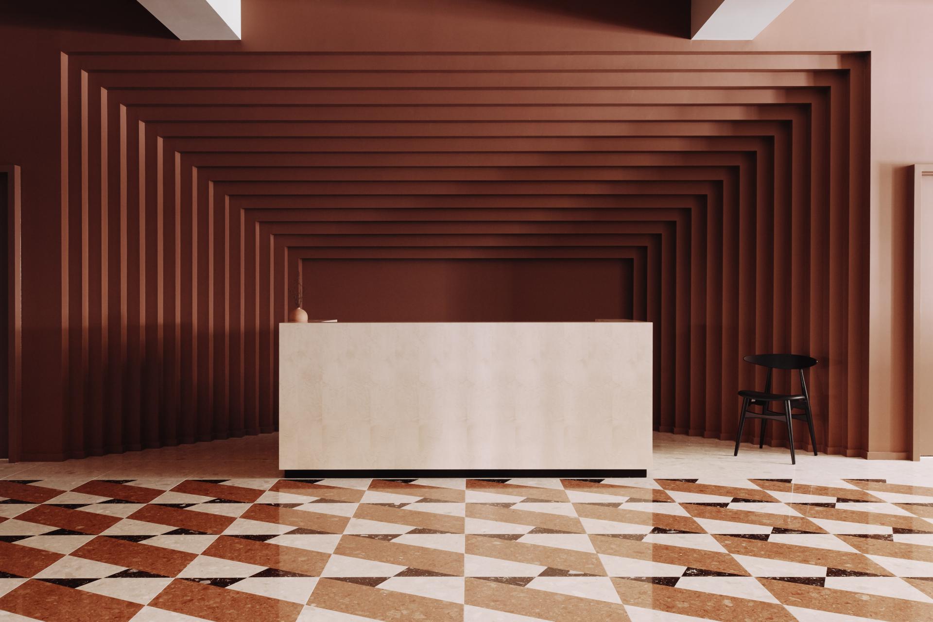 Stylish reception area at Summit House featuring geometric flooring and warm, textured walls for a calming workspace atmosphere.