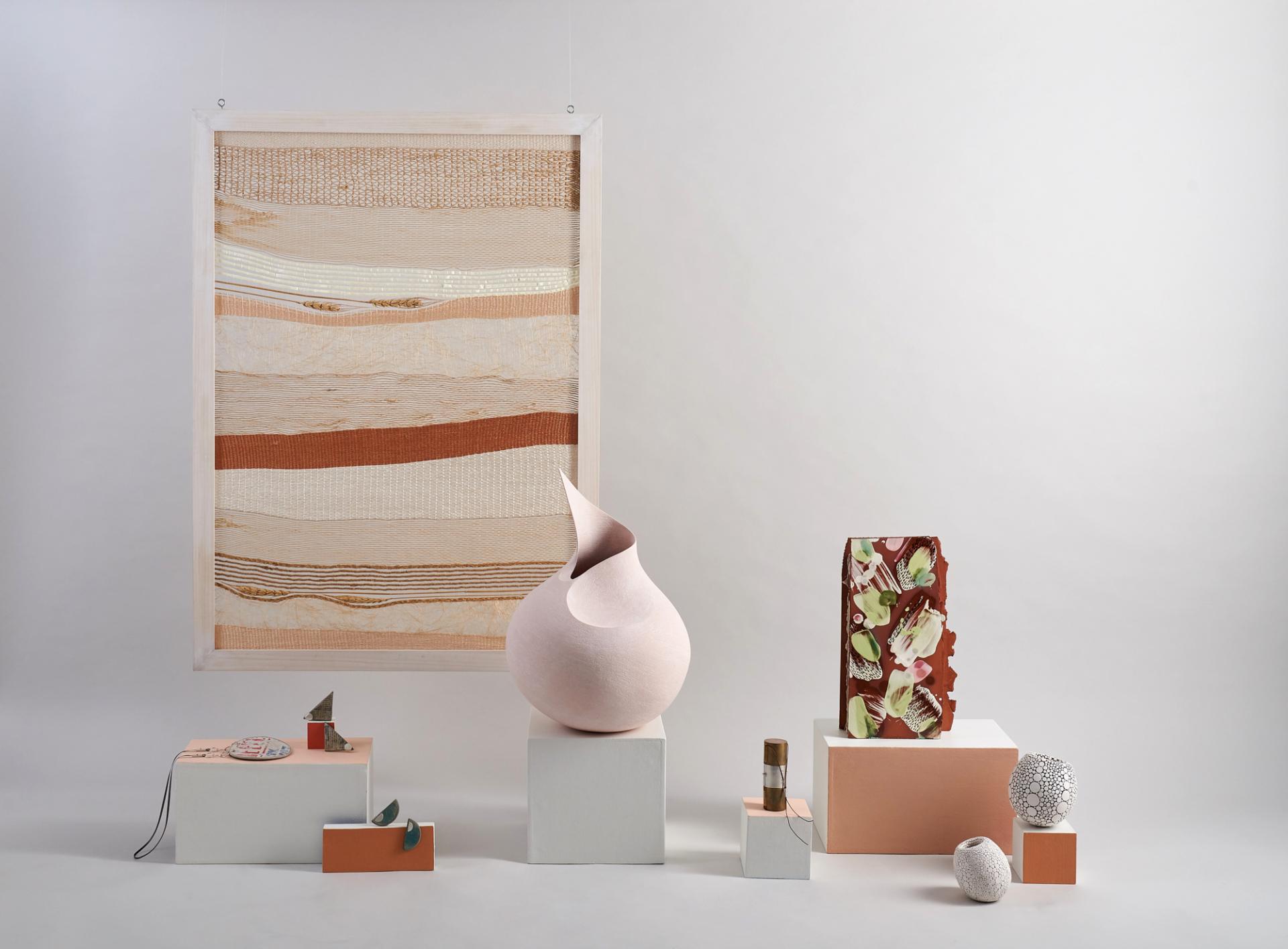 Contemporary art display featuring sculptural pieces and woven textile, showcasing innovative designs by emerging creatives.