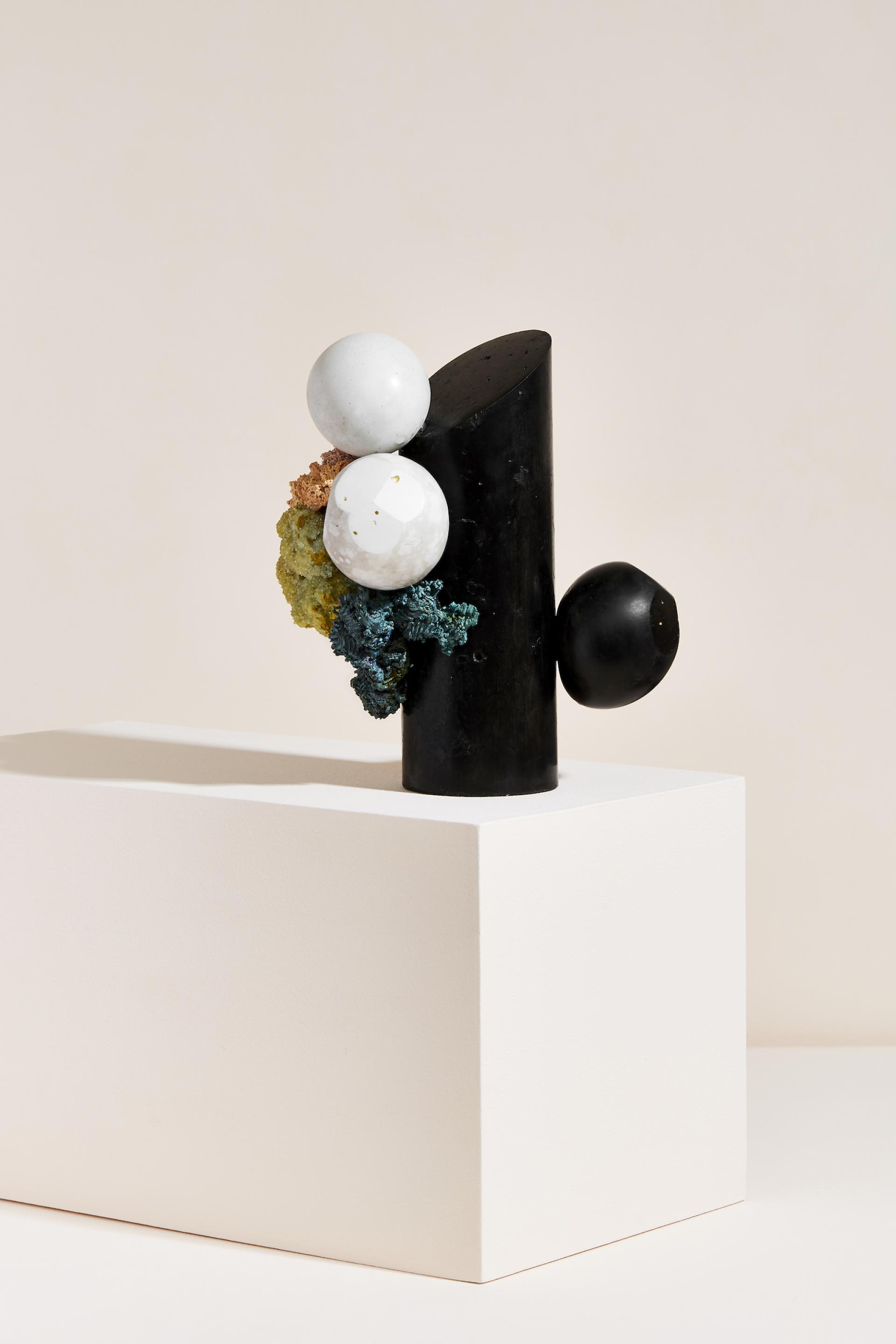Abstract sculptural piece featuring black and white spheres with textured elements, highlighting the artistry of sculptor Vic Wright.