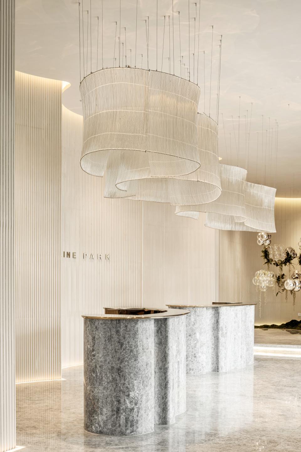 Elegant reception area featuring sculptural lighting, marble counters, and a serene atmosphere in the floating urban metropolis design.