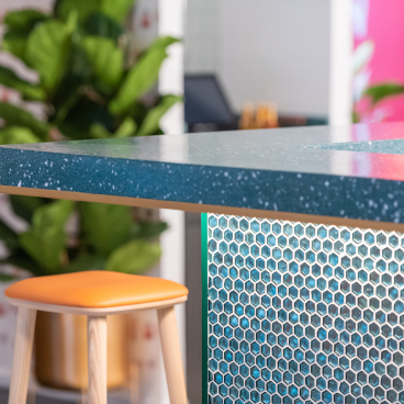 Stylish bar counter featuring a blue speckled surface and geometric design, showcasing modern and playful design elements.