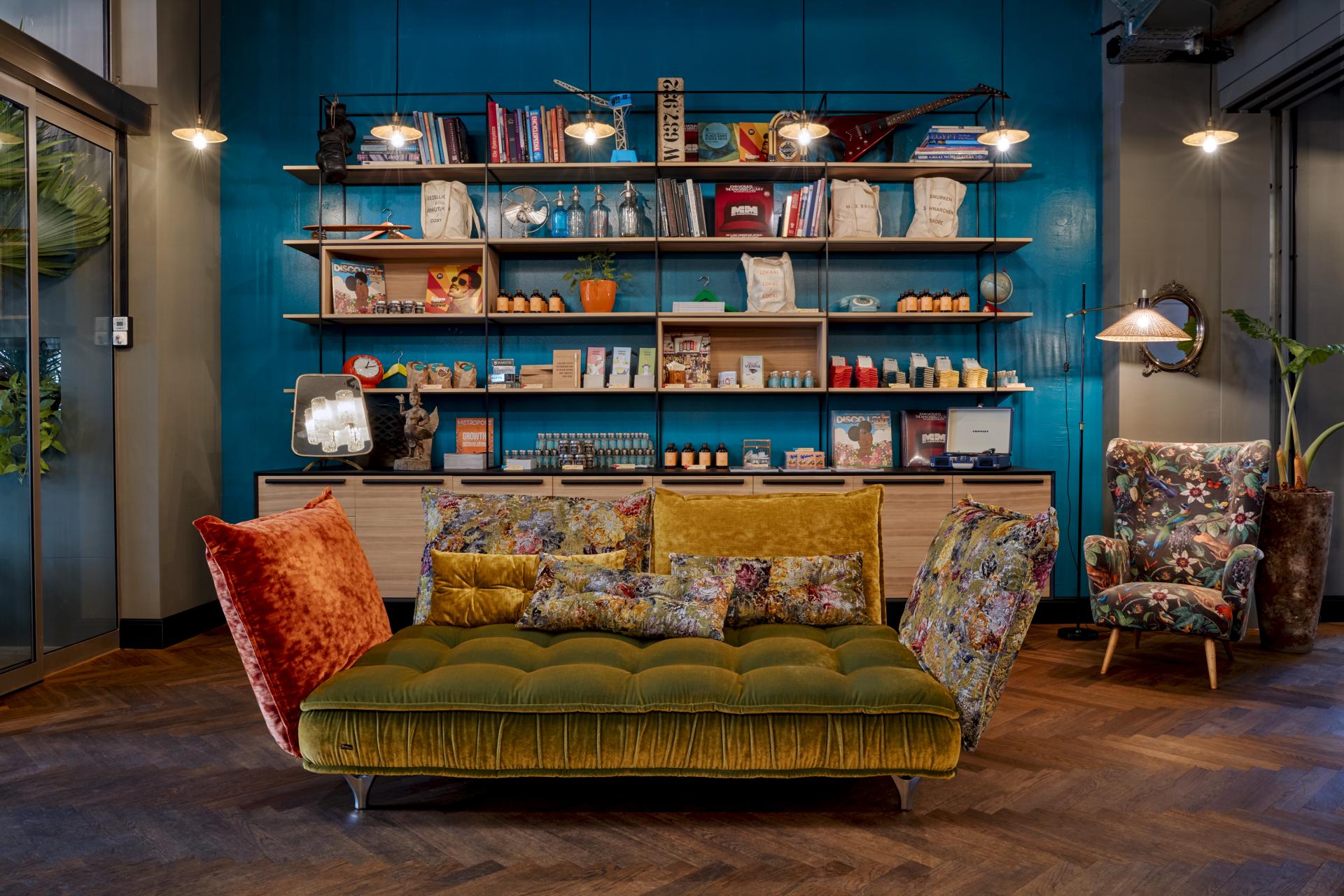 Stylish lobby seating at Max Brown 7th District, featuring vibrant decor and artistic shelves in Vienna's Neubau neighborhood.
