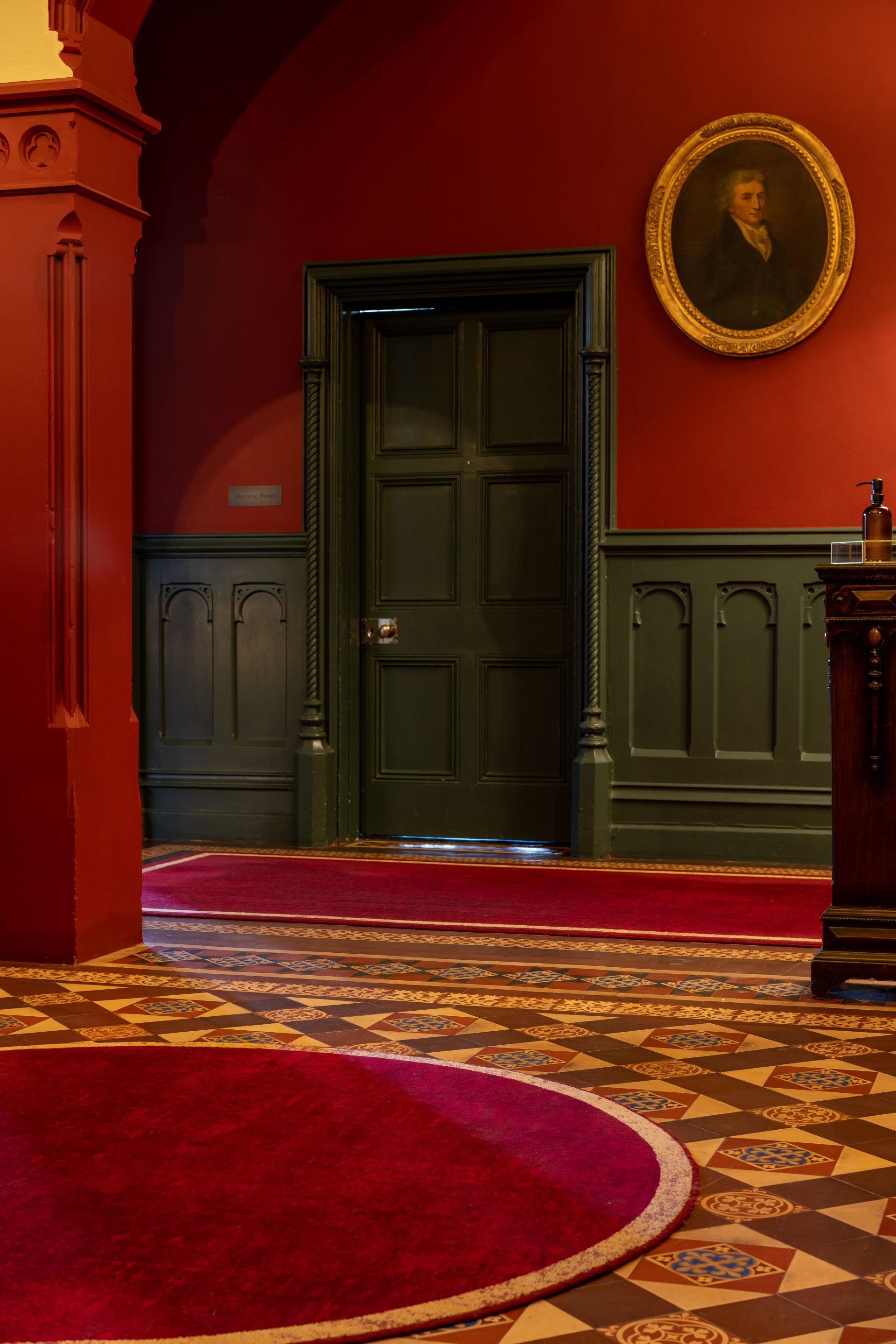 Luxurious red carpet and intricate patterned flooring complement The Elvetham’s historic interior design and elegant decor.