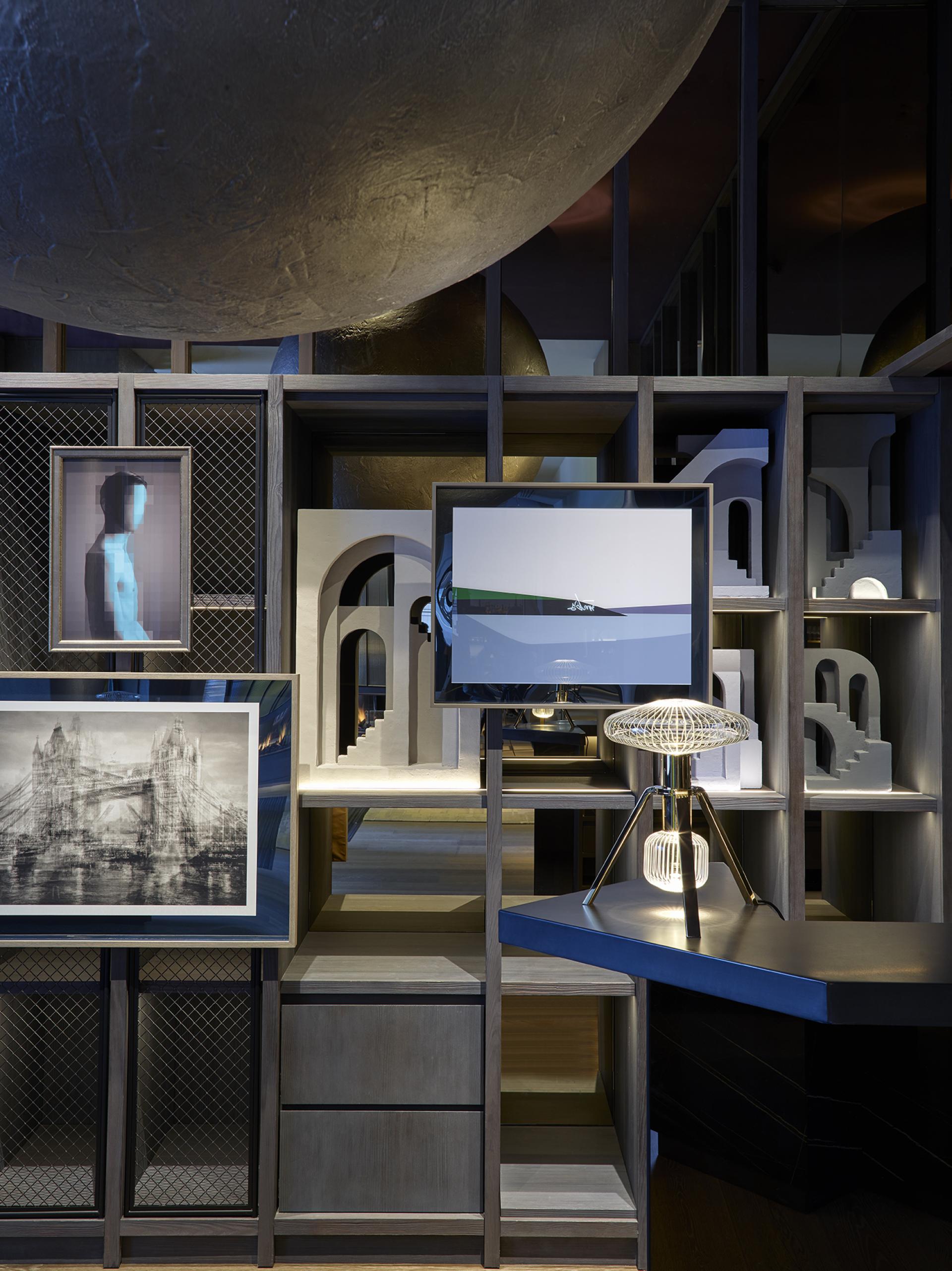 Theatrical interior design of Leicester Square hotel featuring unique artworks, sculptures, and modern lighting elements.