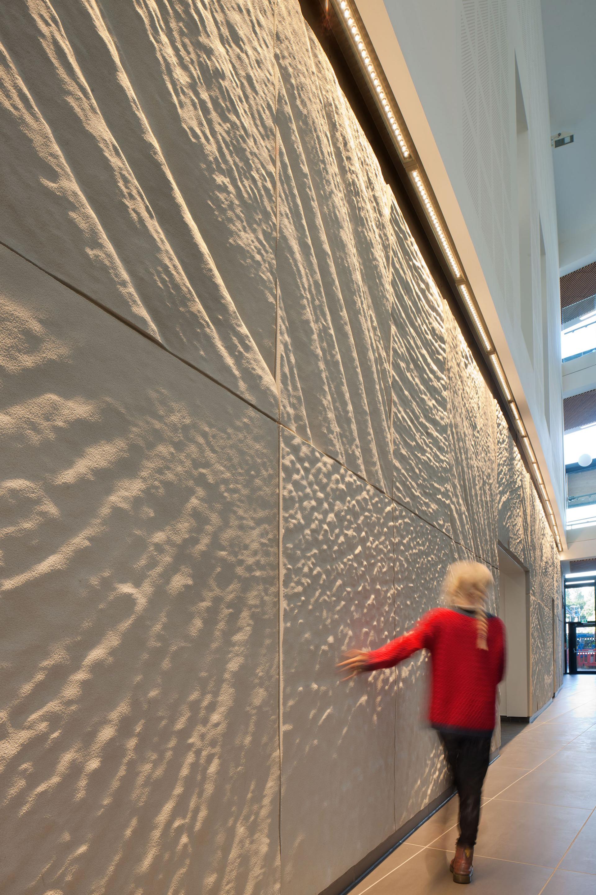 Textured wall with ambient lighting, enhancing the uplifting healthcare environment designed by HLM for NHS Lothian.