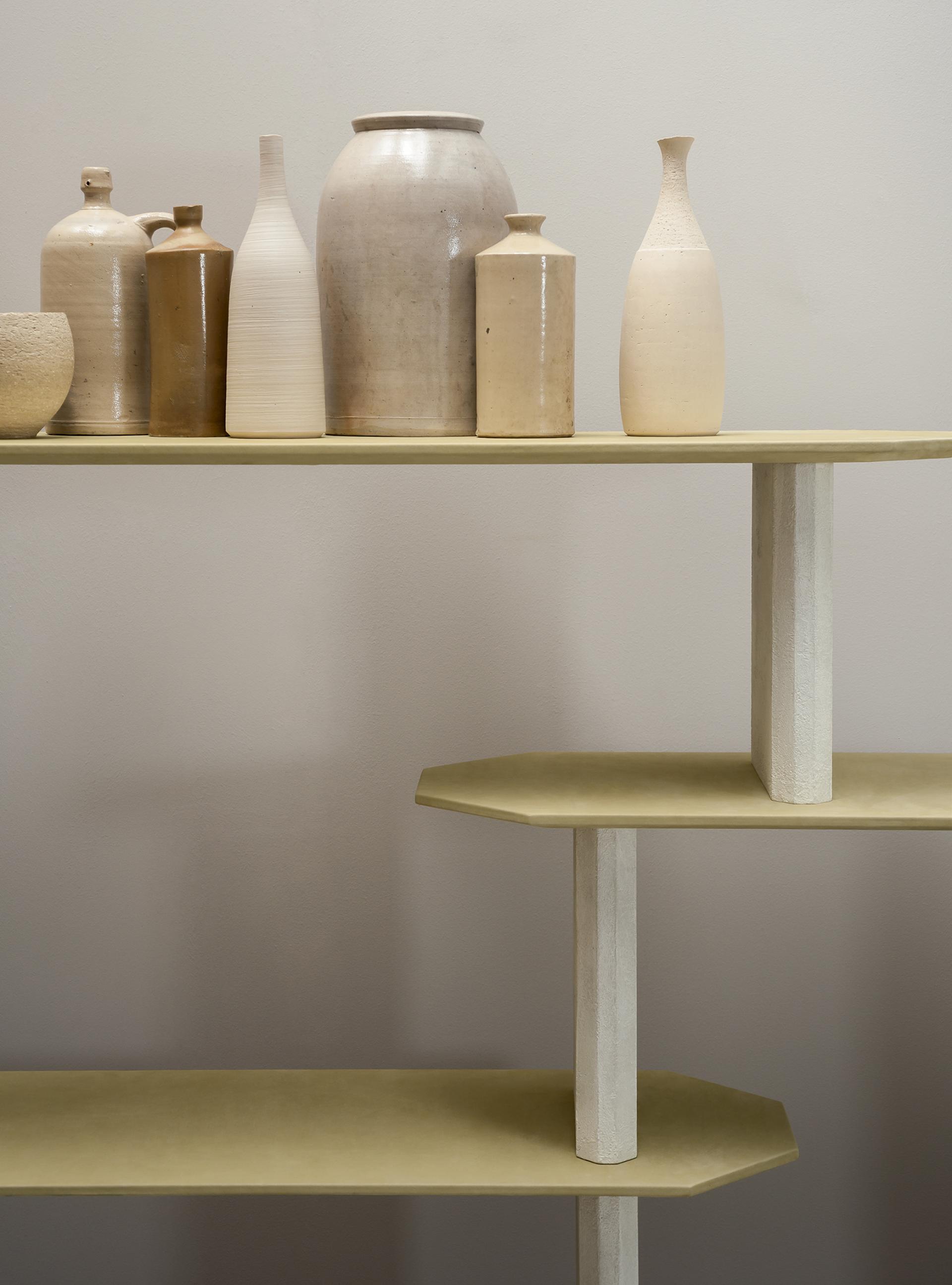 Shelf displaying a variety of contemporary ceramic vases in earthy tones, showcasing Baxter's luxury design aesthetic.