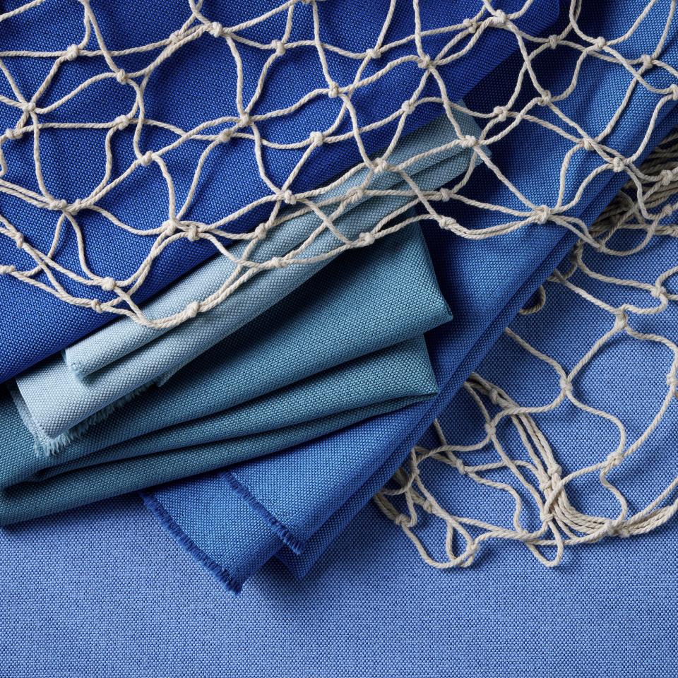 Sustainable blue fabrics and fishing net highlighting Camira's commitment to combat marine plastic pollution with SEAQUAL Initiative.
