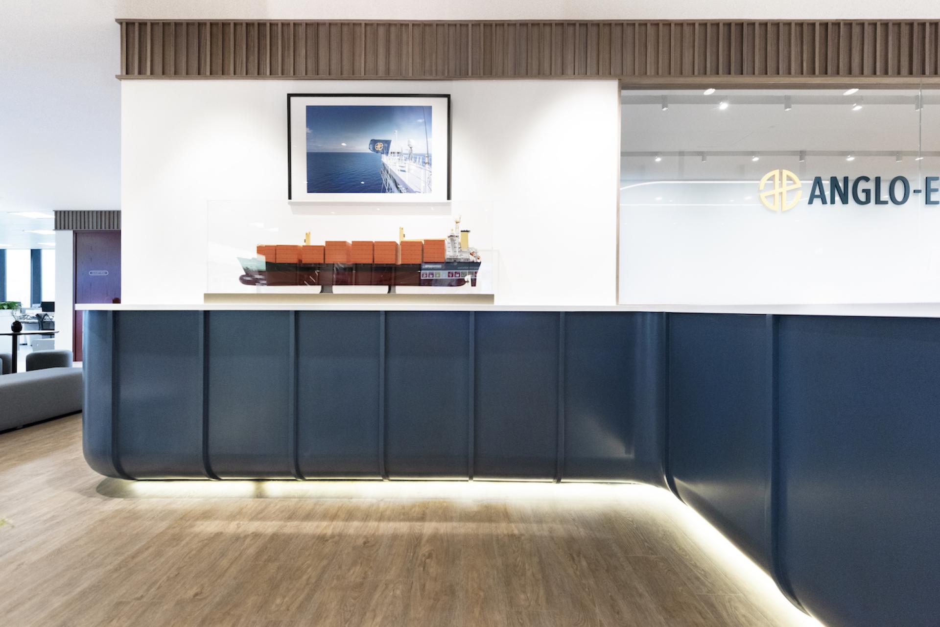 Modern office reception area showcasing a model ship and sleek design elements, reflecting Bean Buro's nautical workplace concept.