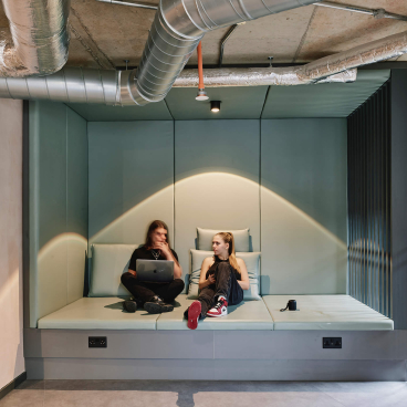 Modern student lounge area at The Tannery in Leicester, featuring two students engaging with a laptop.