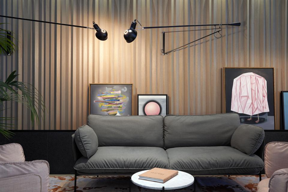 Stylish interior of PURO Kraków Kazimierz featuring a cozy sofa, modern artwork, and sleek wall lights.