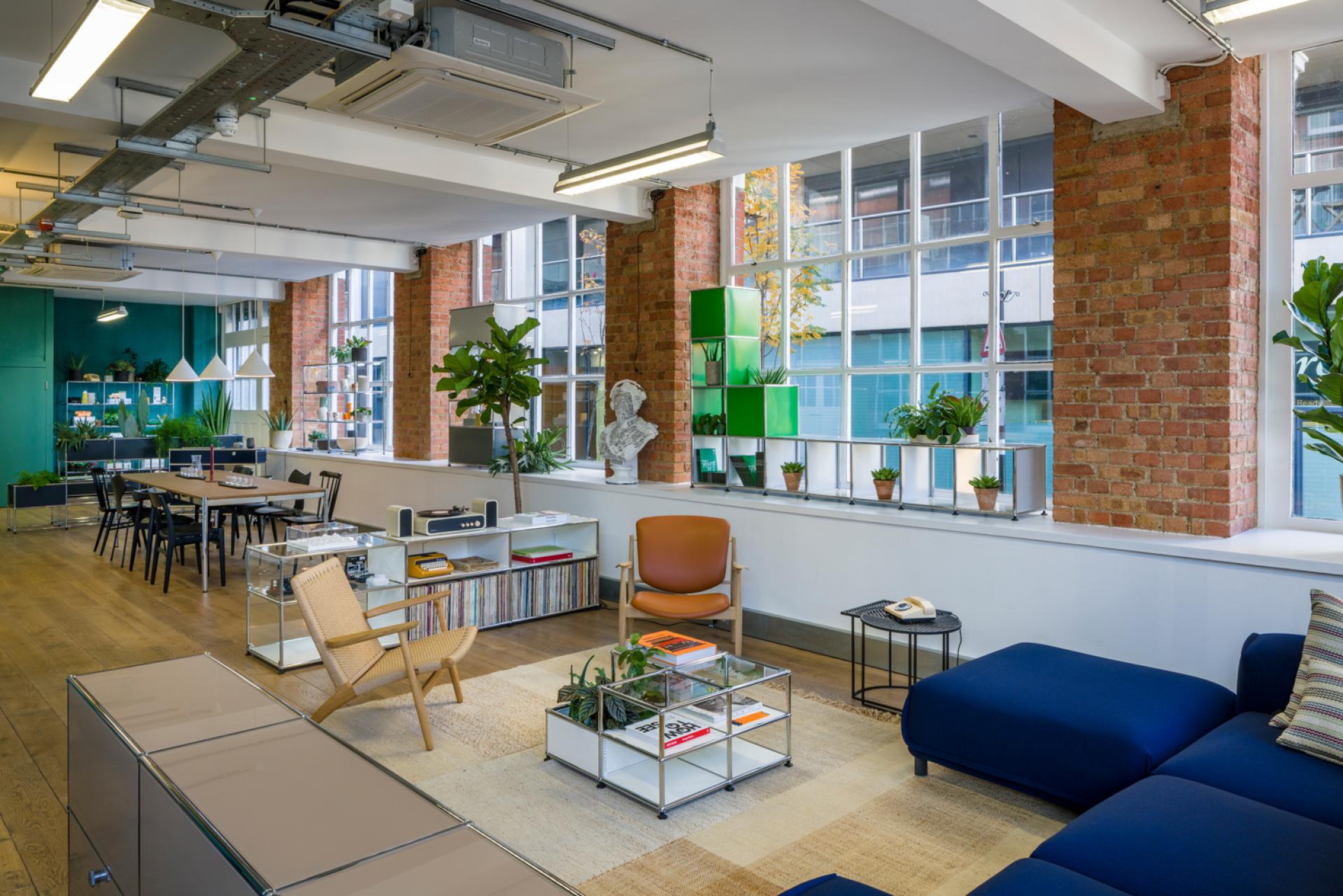USM's Clerkenwell showroom features modern modular furniture, greenery, and stylish decor in a vibrant, inviting space.